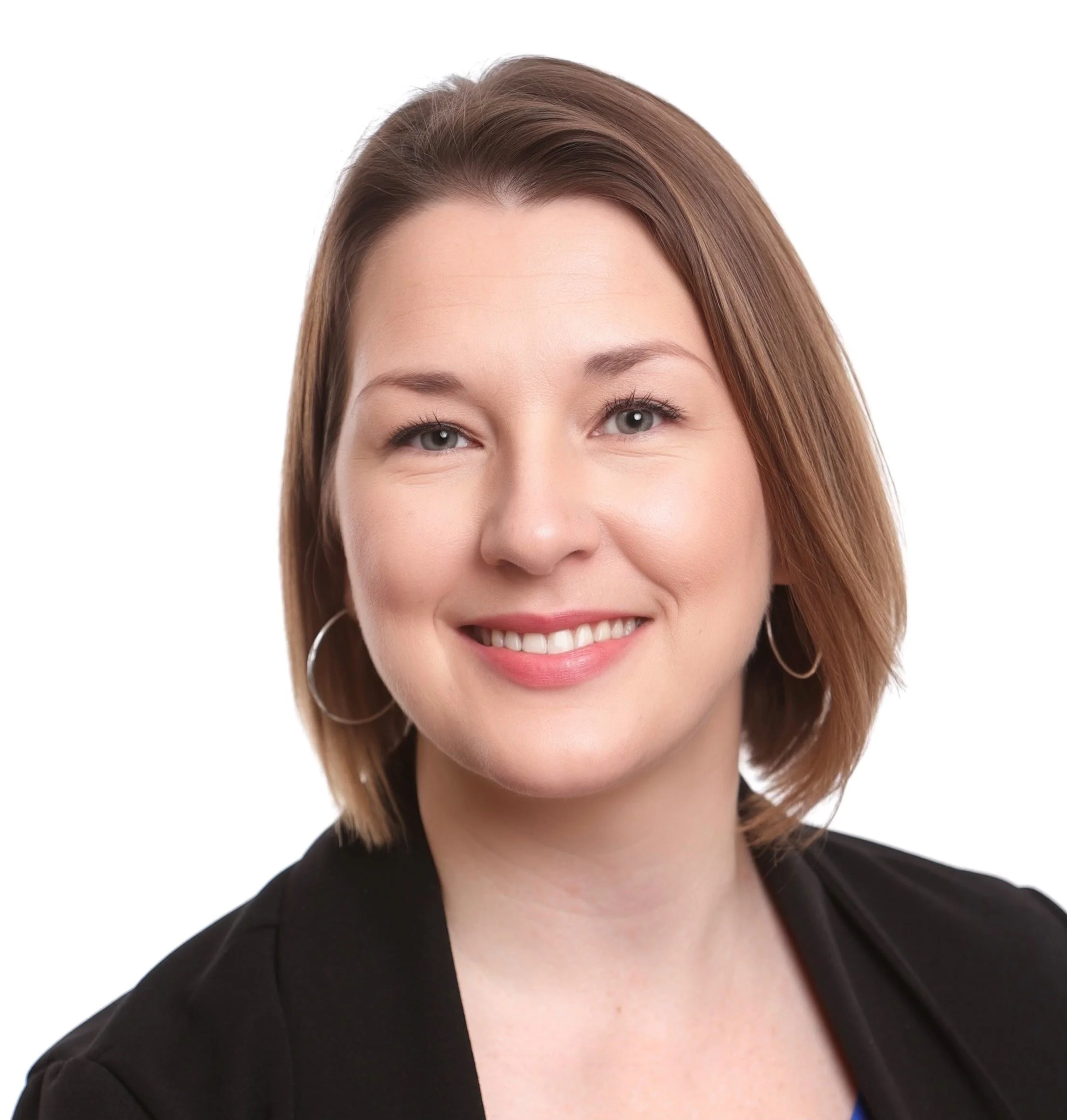 A woman with shoulder-length brown hair, wearing a black blazer and hoop earrings, smiling against a white background.