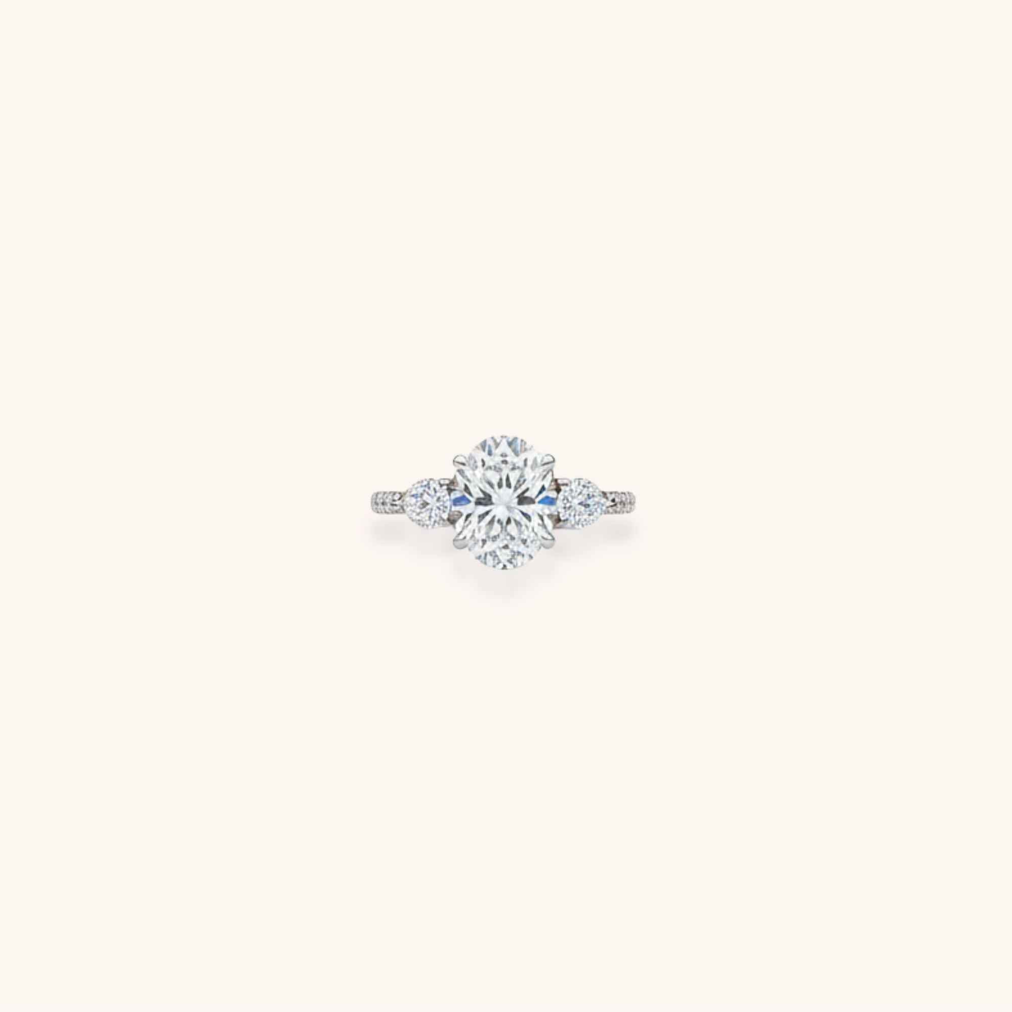 Diamond engagement ring with a large central diamond and smaller side diamonds on a plain background.
