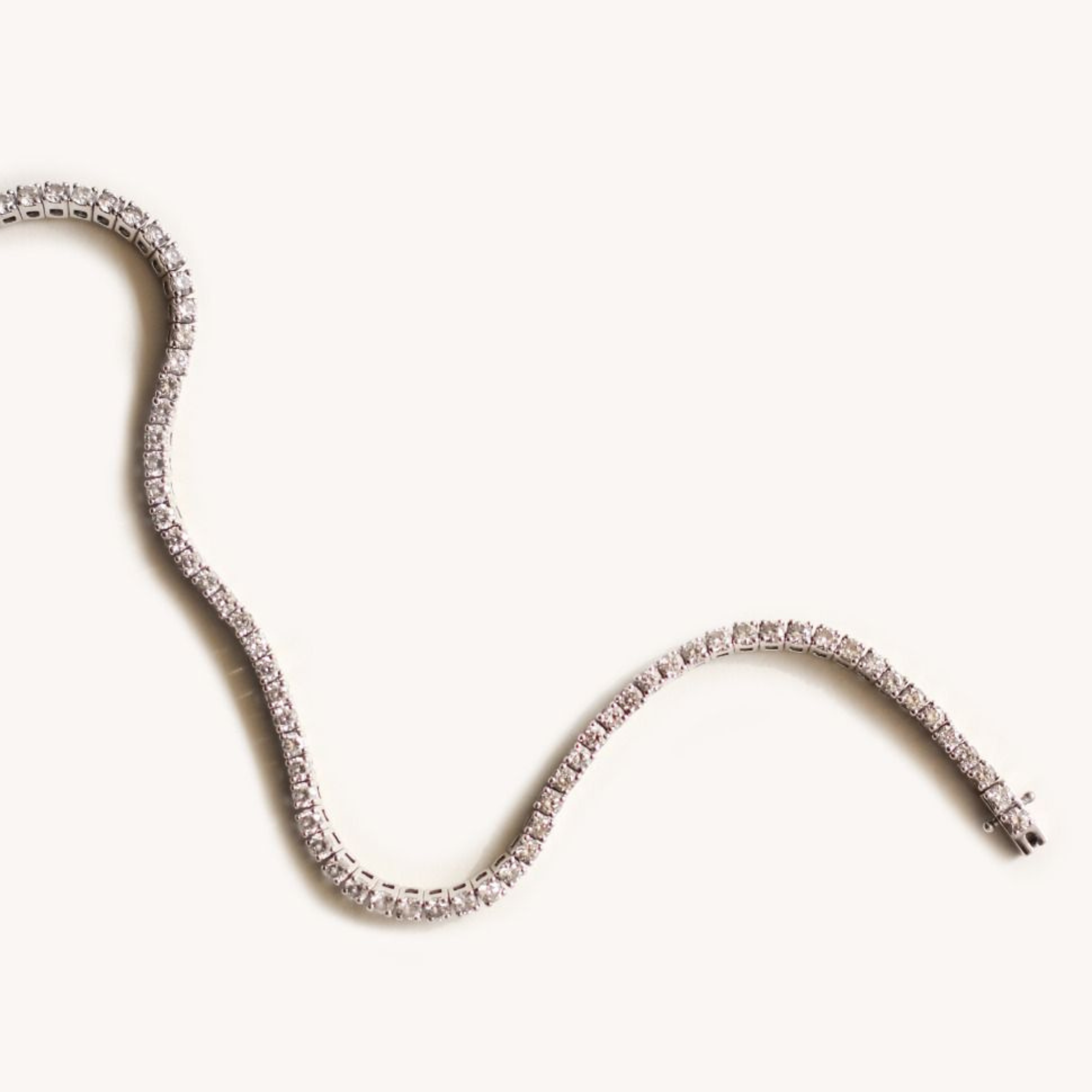 Silver necklace with small, sparkling diamonds on a plain white background.