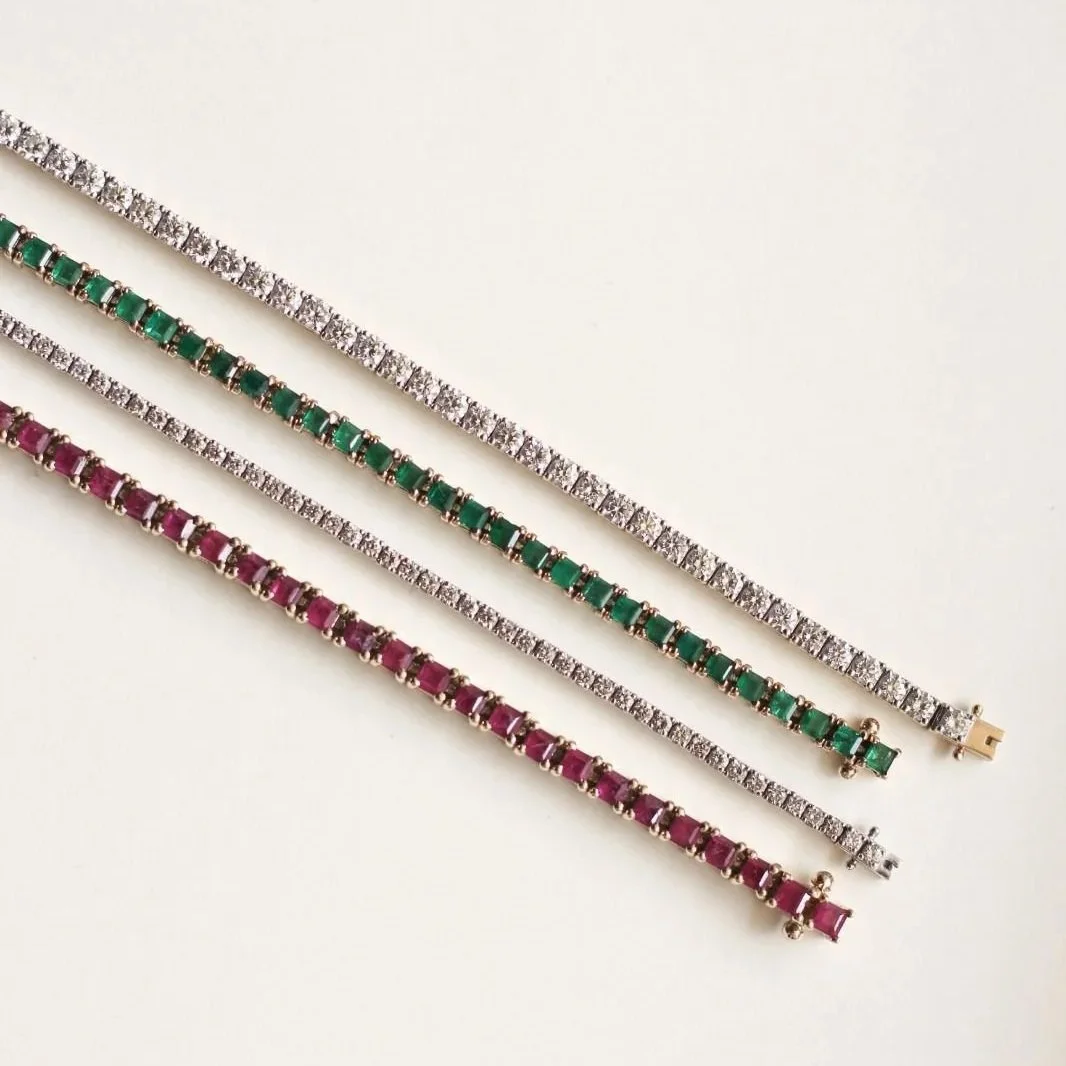 Four elegant tennis bracelets with gemstones, diamonds and gold settings on a white background.