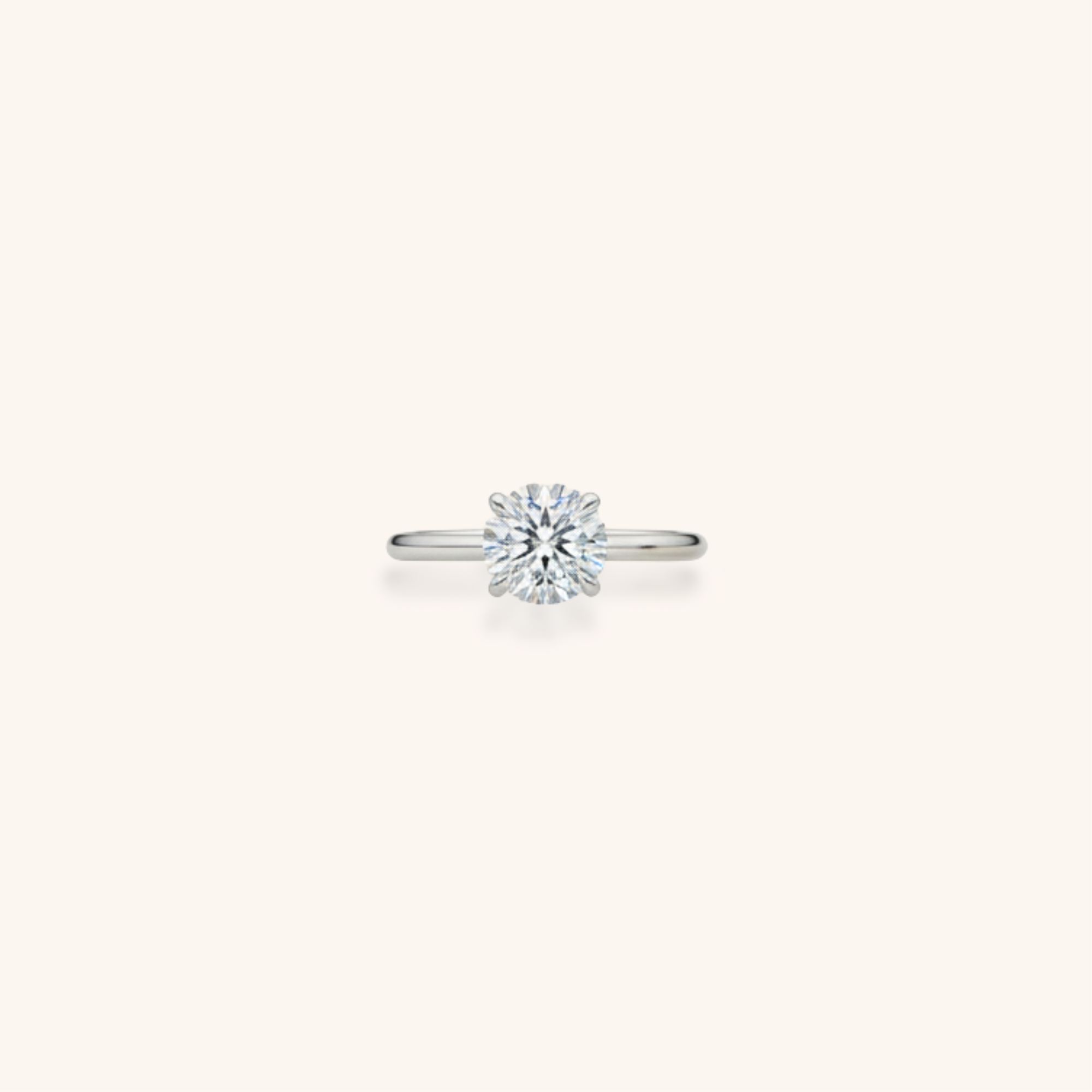 Solitaire diamond ring on a plain light background.