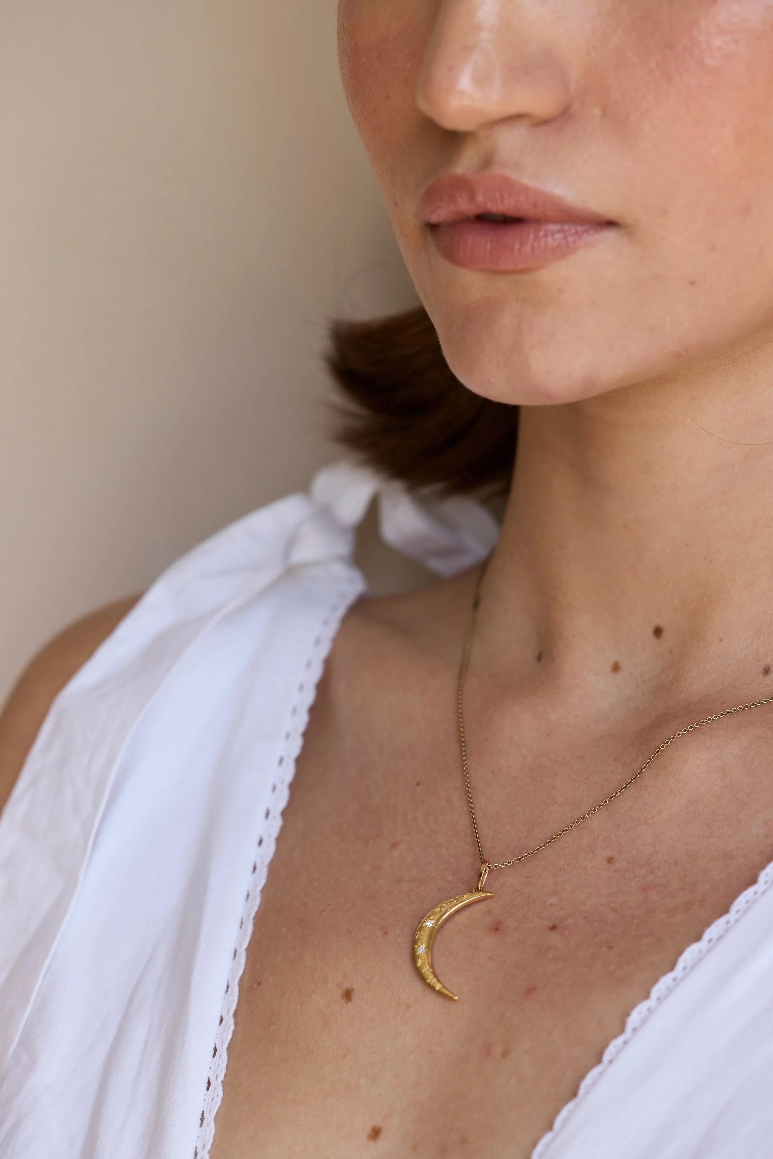 Model wearing diamond crescent moon necklace in 14K gold, elegant jewelry.