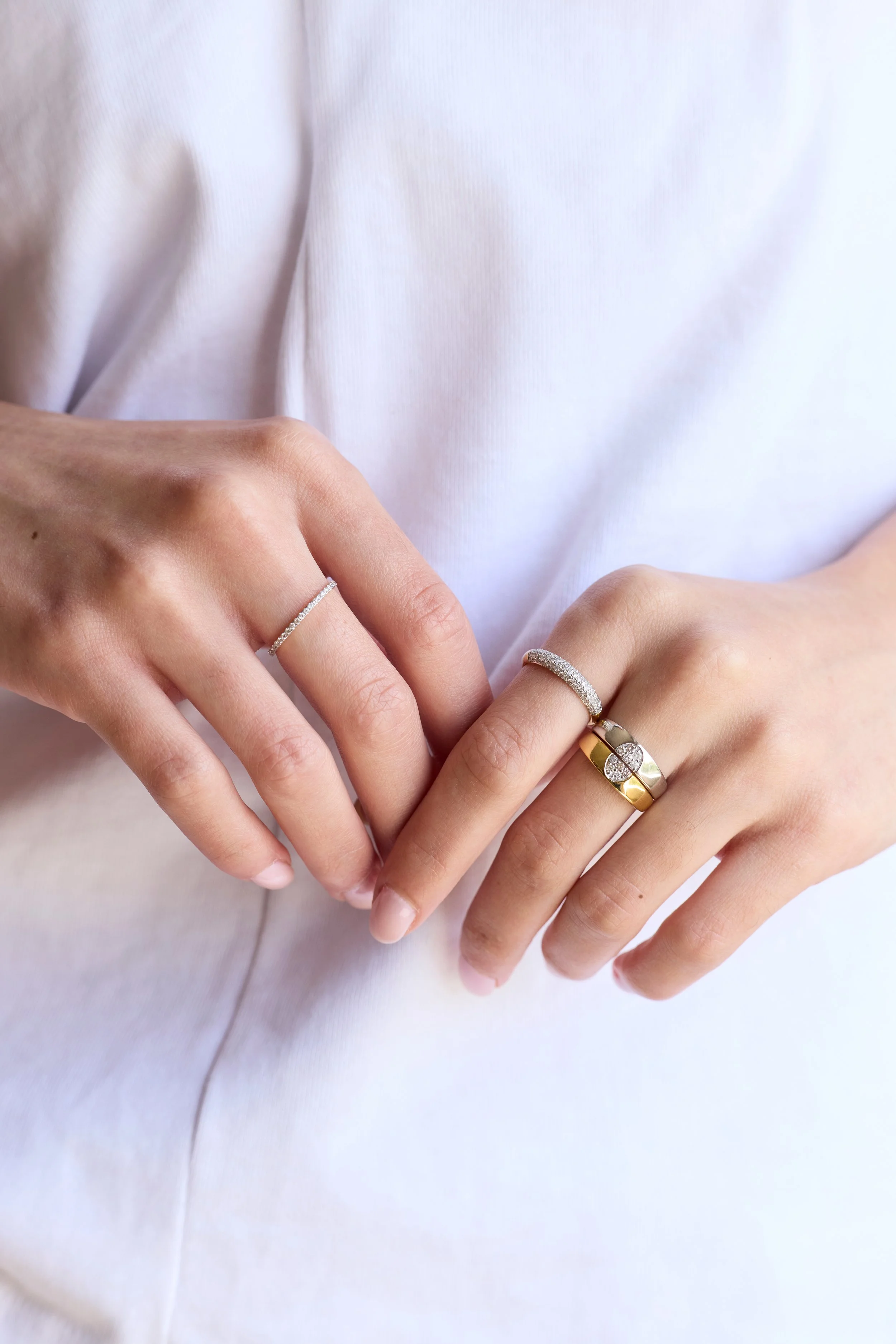Model wearing gold diamond eternity band, classic wedding ring style.