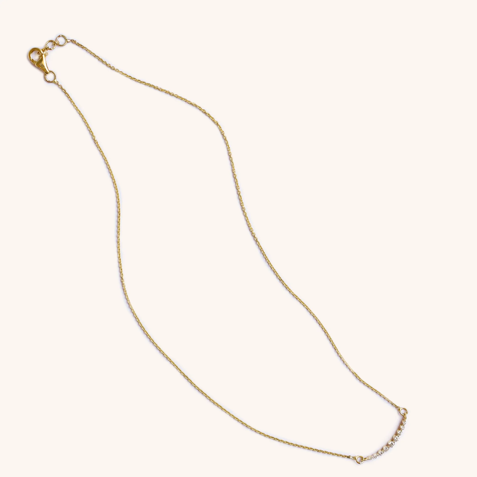 Close-up of diamond bar detail in 14K gold, handmade fine necklace.