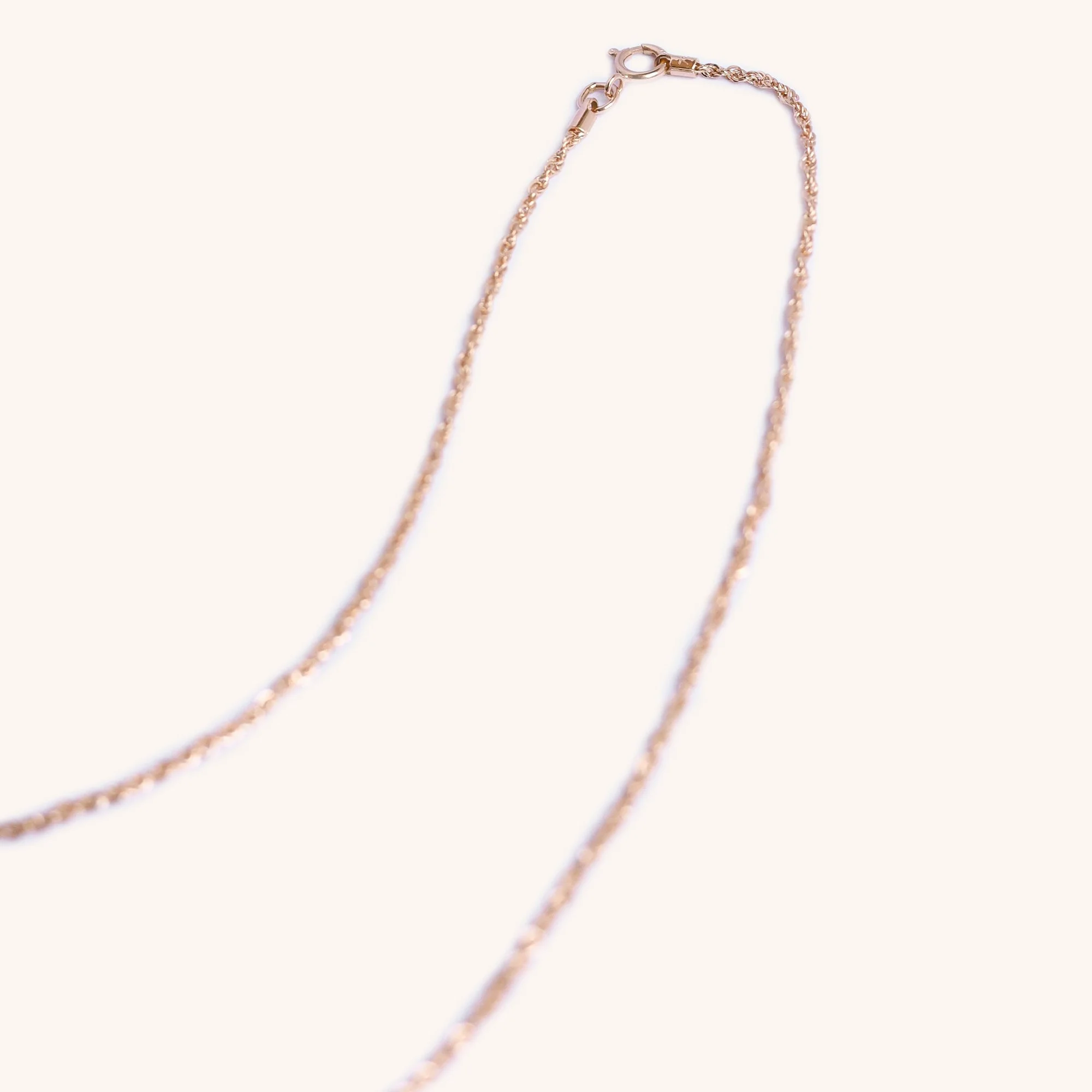 Close-up of twisted rope design in 18K rose gold, artisan gold chain.