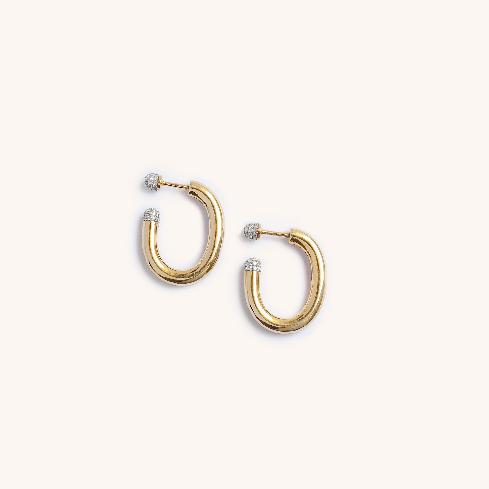 Pair of gold hoop earrings with diamond accents on a white background.