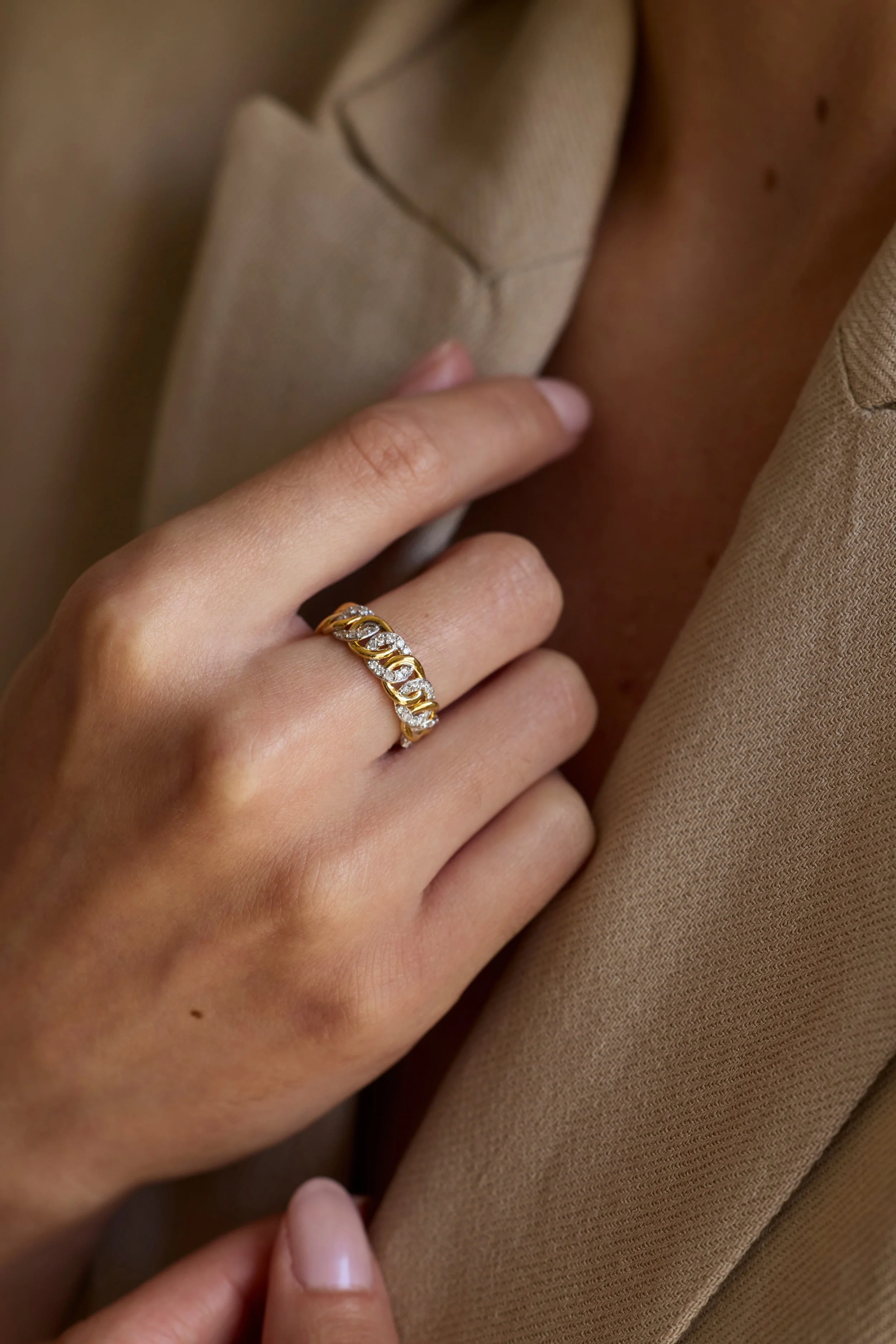 Model wearing two-tone gold link band with diamonds, fine jewelry design.