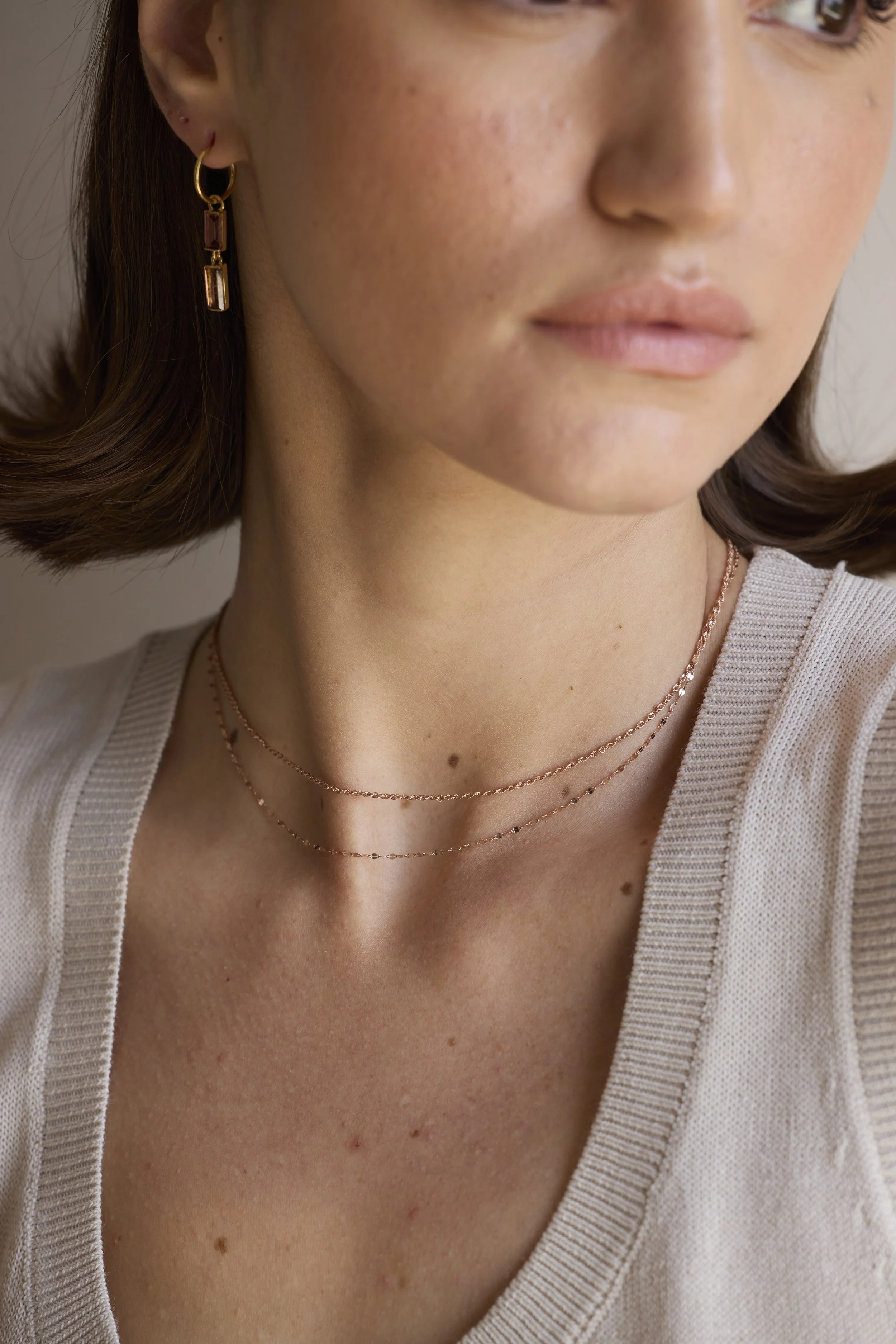 Model wearing bold 18K rose gold rope chain, statement fine jewelry piece.