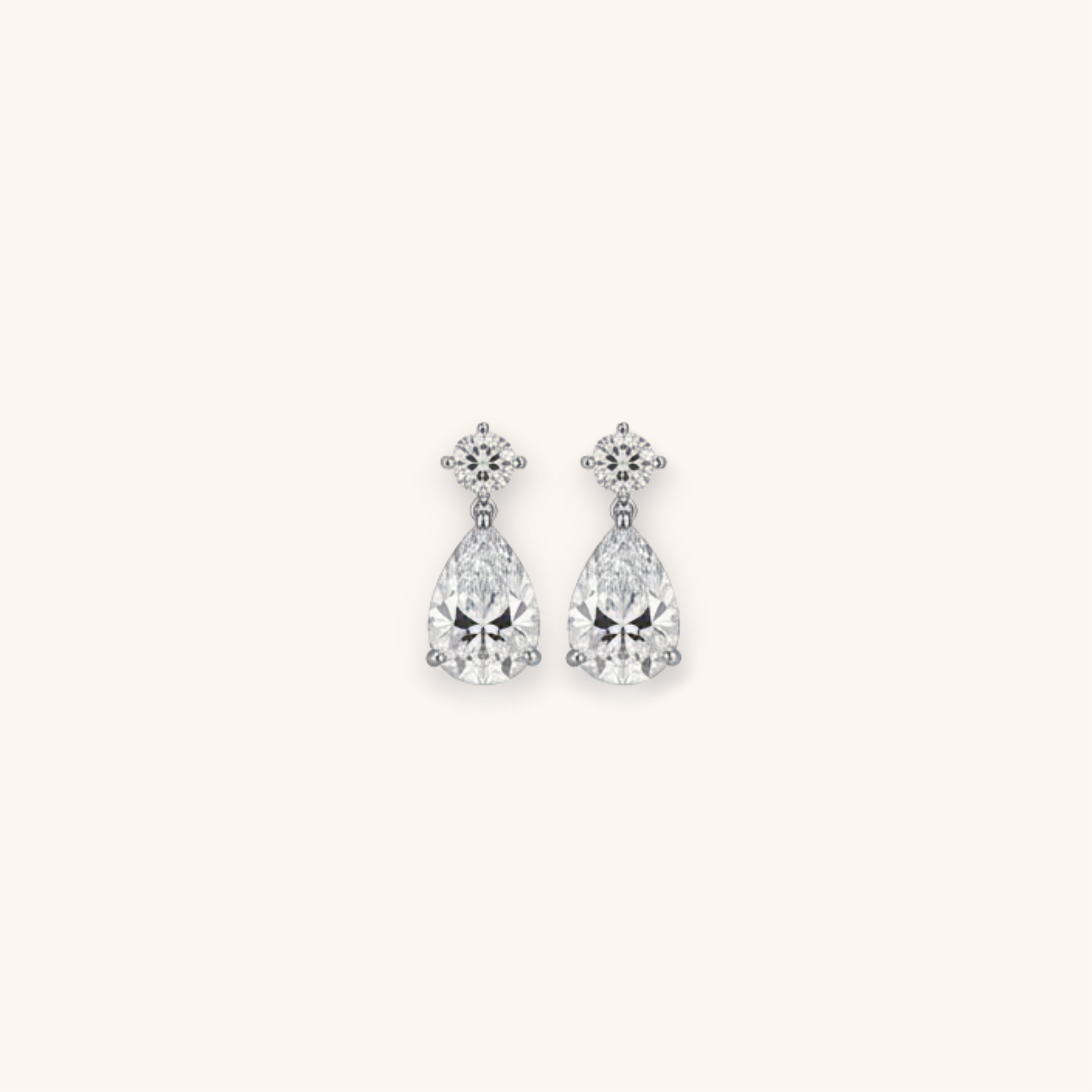 A pair of dangling diamond earrings with a floral-shaped top and teardrop-shaped diamonds hanging below.