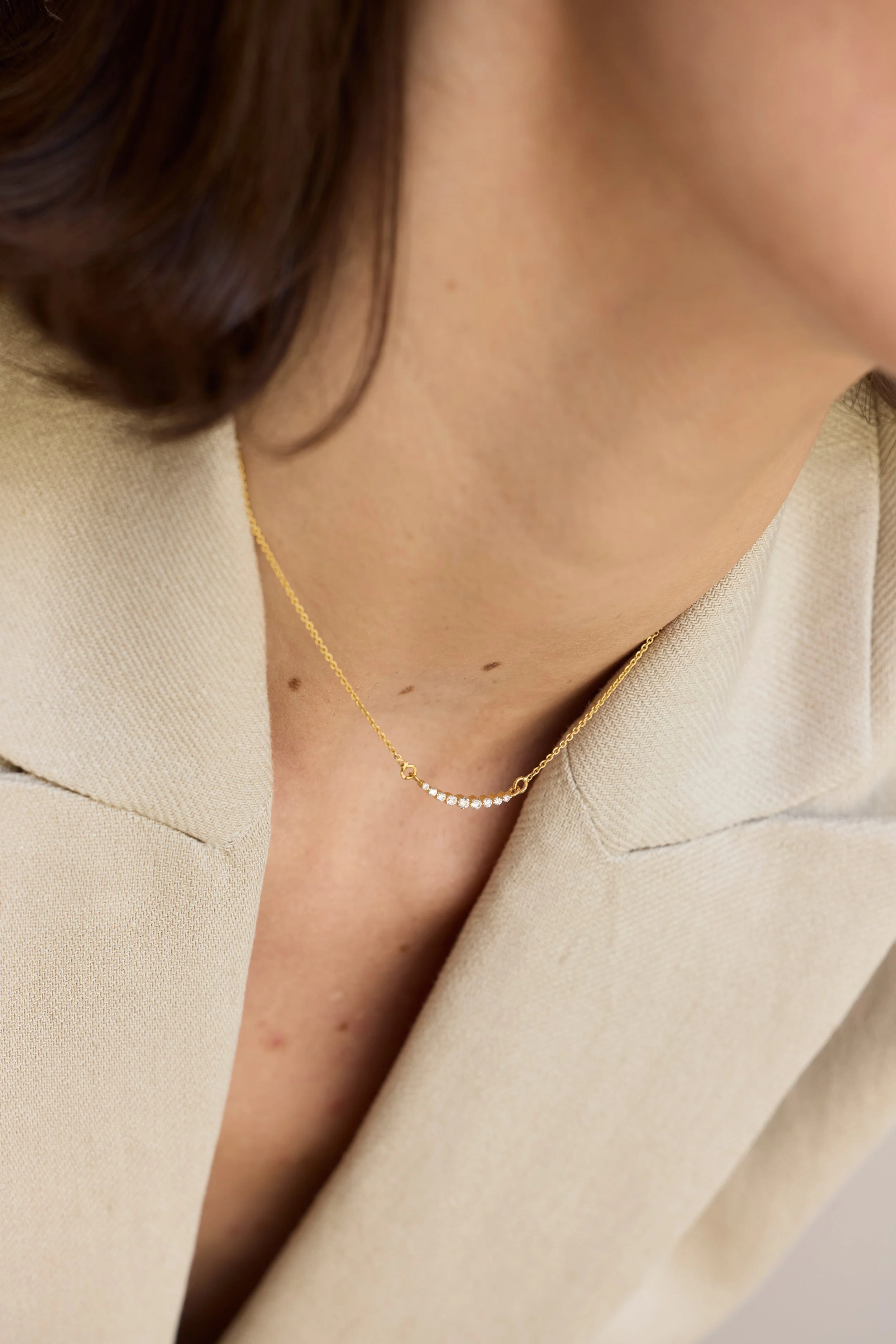 Layered 14K recycled gold chains and a natural diamond pendant at a woman's collarbone — Zikr Chains & Pendants Collection