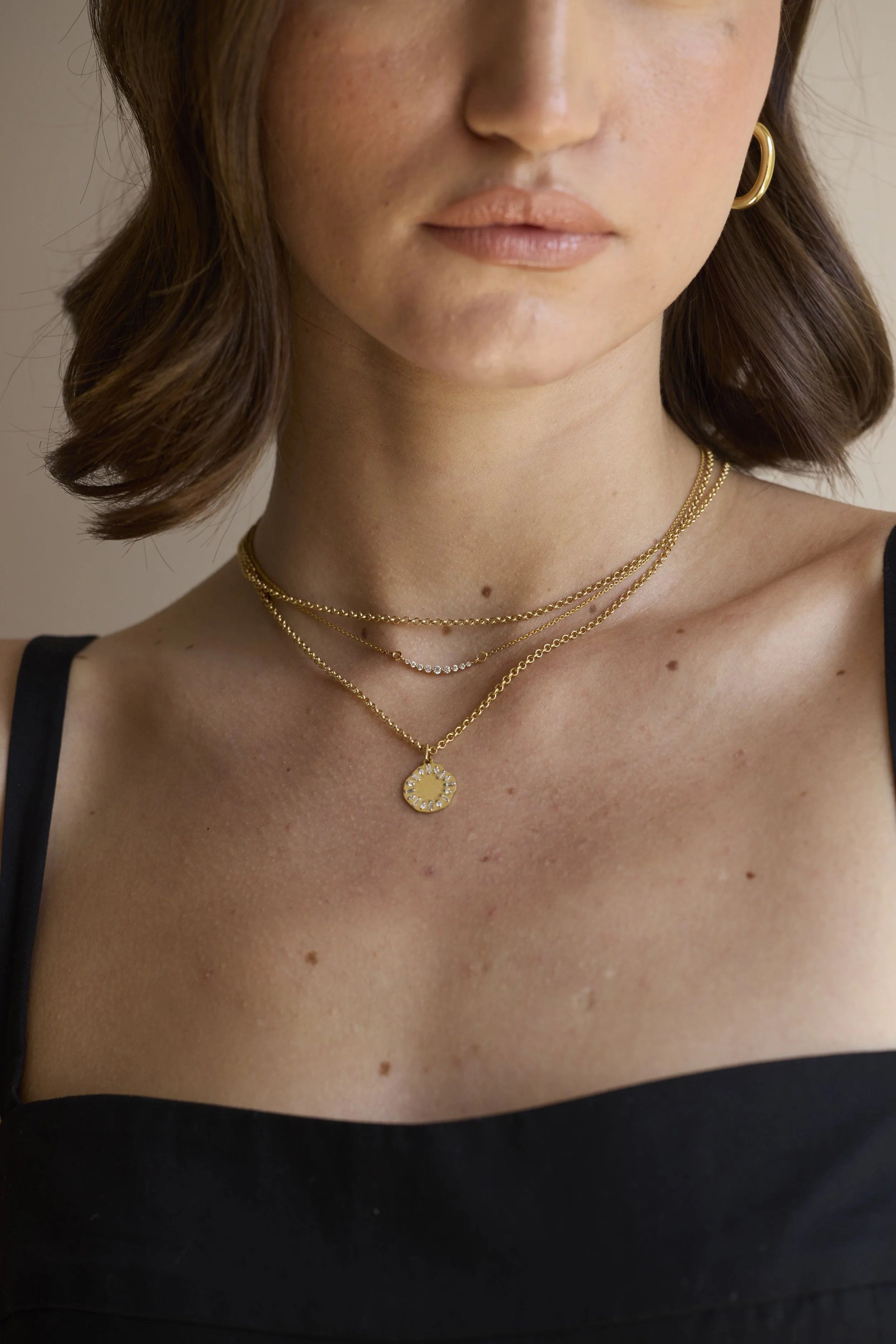Model wearing 14K gold diamond line necklace, elegant luxury design.