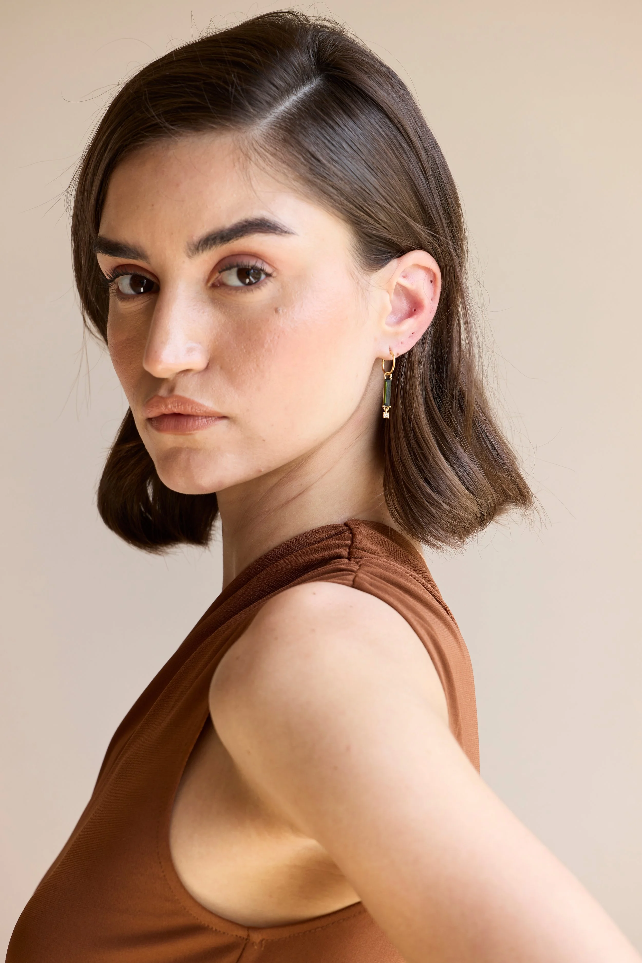 Model wearing 14K gold green tourmaline and diamond earrings, elegant gemstone jewelry that balances natural beauty with radiant luxury.