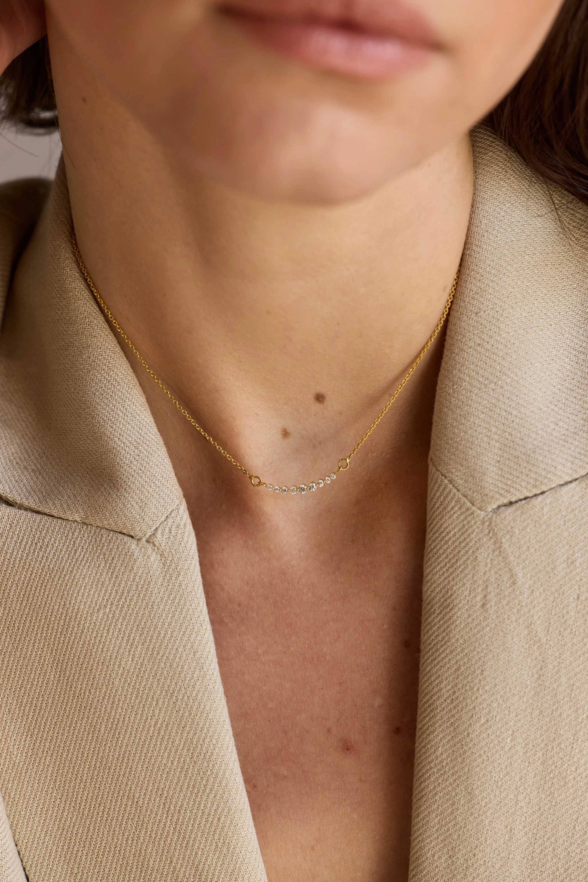 Model wearing 14K gold diamond line necklace, elegant luxury design.