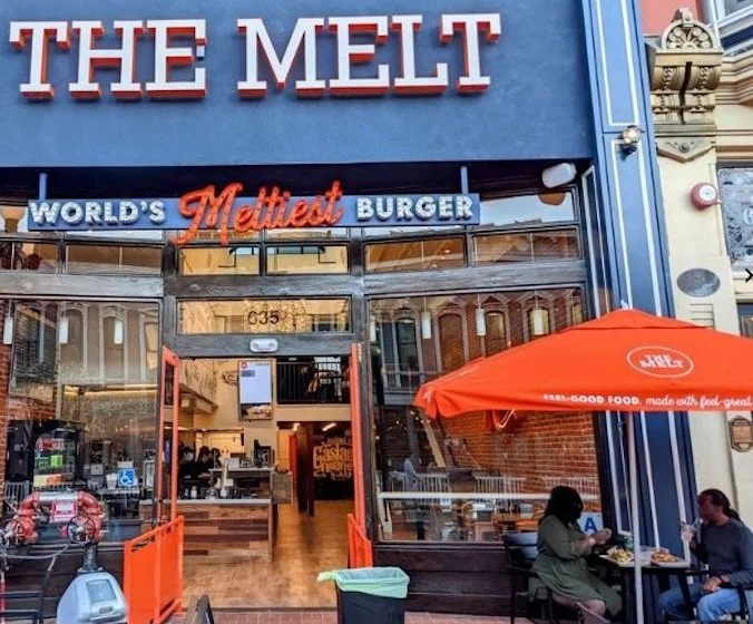 The Melt restaurant storefront with its World’s Meltiest Burger sign and outdoor patio seating.