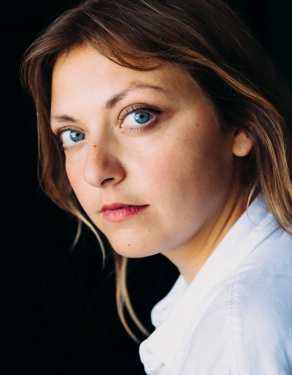 Porträt einer Frau mit blauem Hintergrund, schwarzer Rollkragenpullover