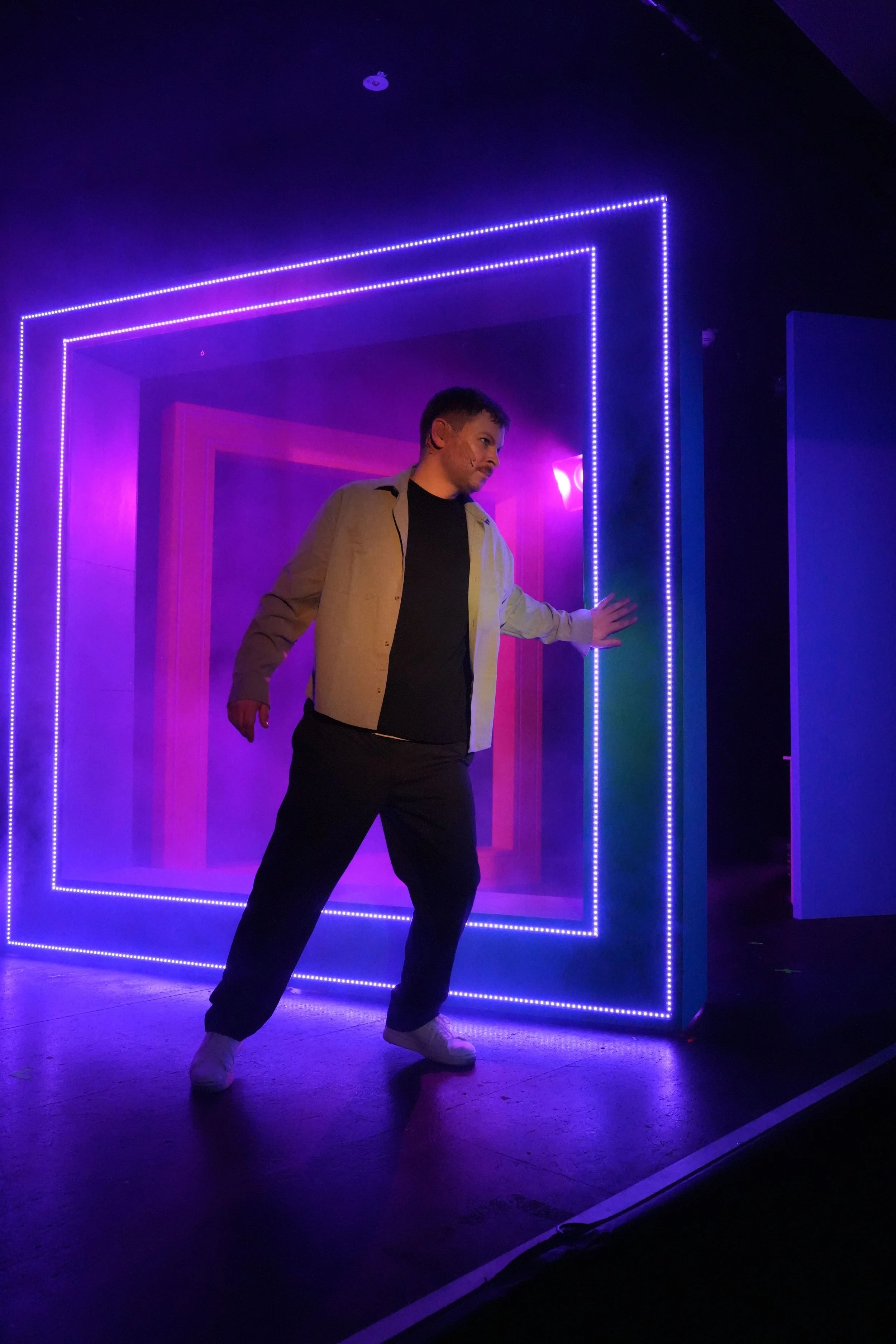 ein Schauspieler dreht einen großen Rahmen mit LED-Lichtern