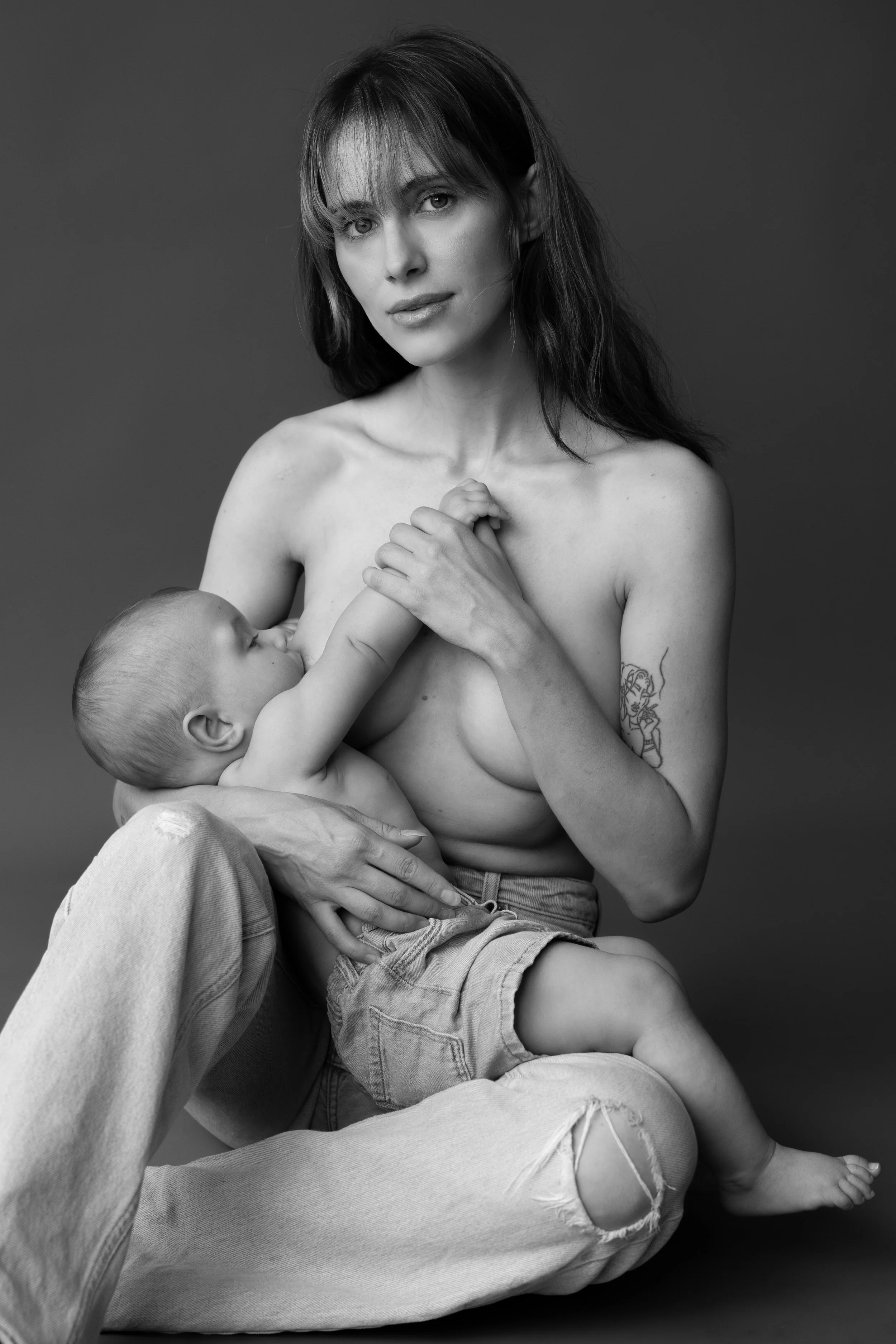 Portret van een moeder die haar kind borstvoeding geeft in de studio