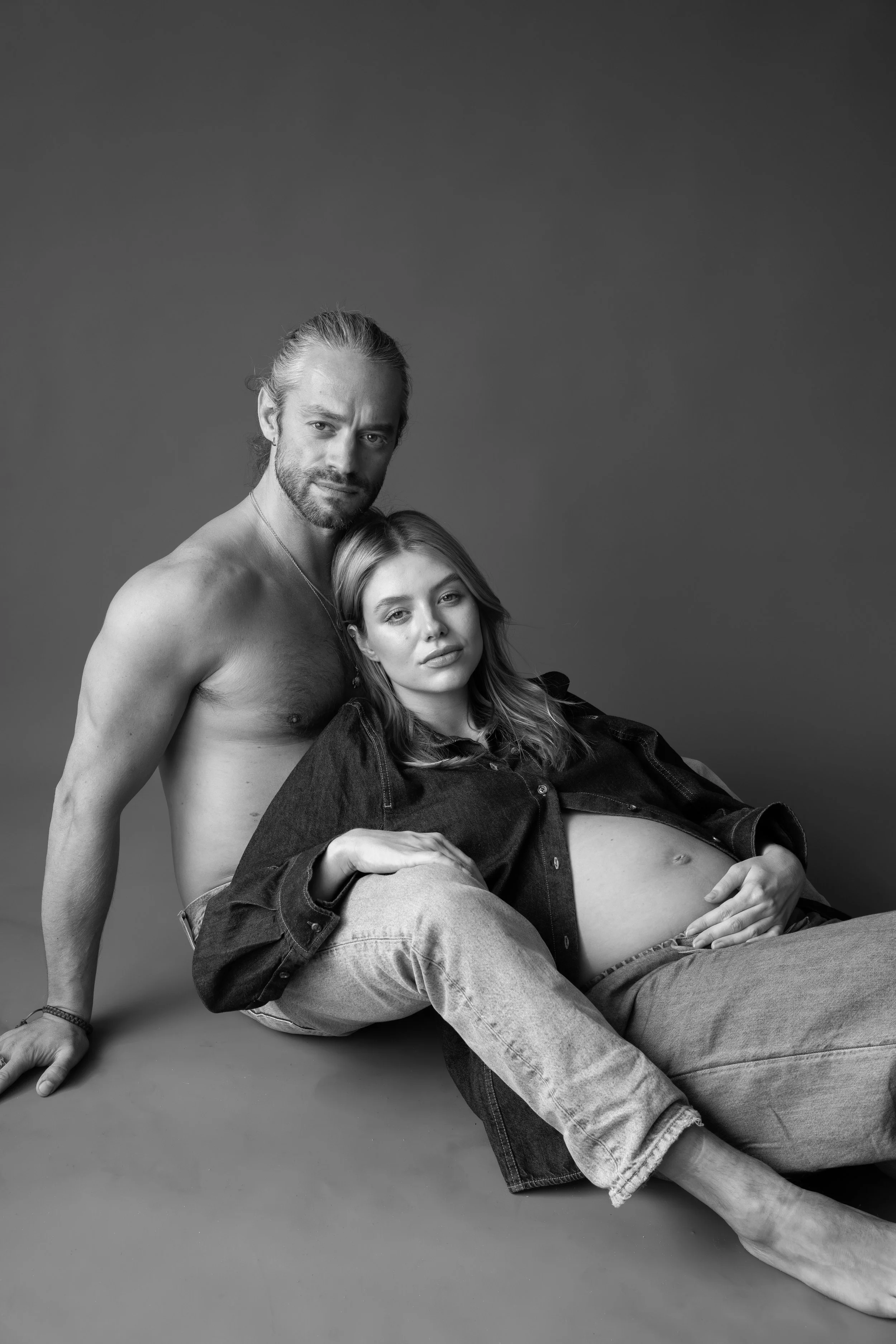 Een zwart-wit portret van een zwangere vrouw met haar partner