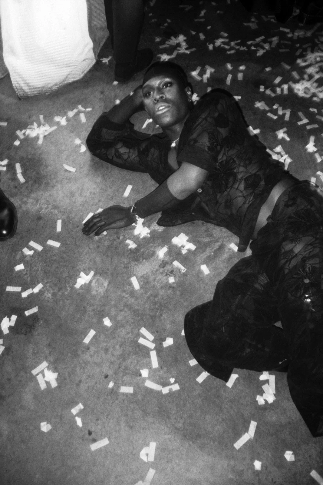 analogue black and white film photograph of a person lying on a confetti-covered floor at Gay Times Honours 2019 capturing queer nightlife atmosphere