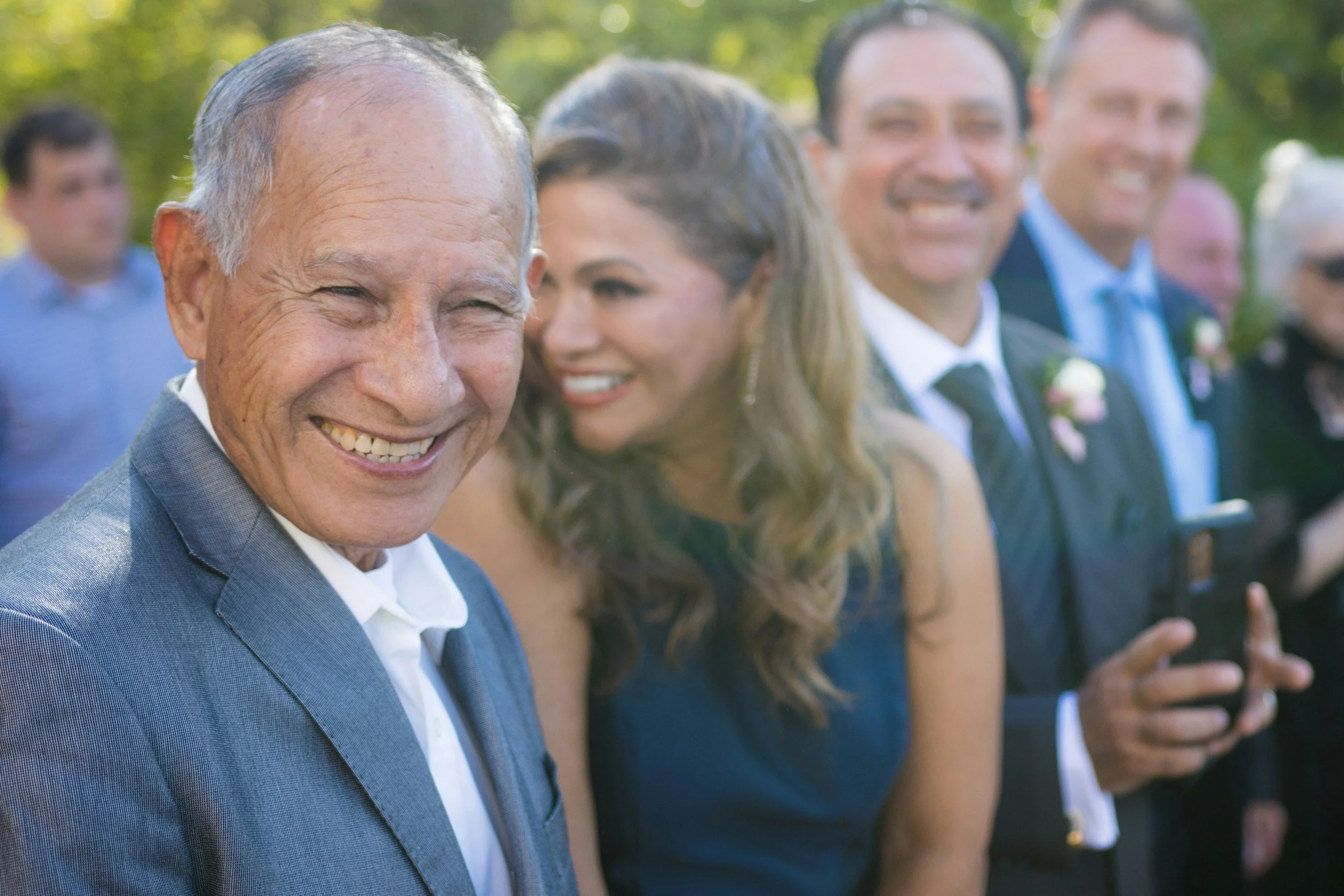 Father and daughter smiling together during an outdoor wedding ceremony