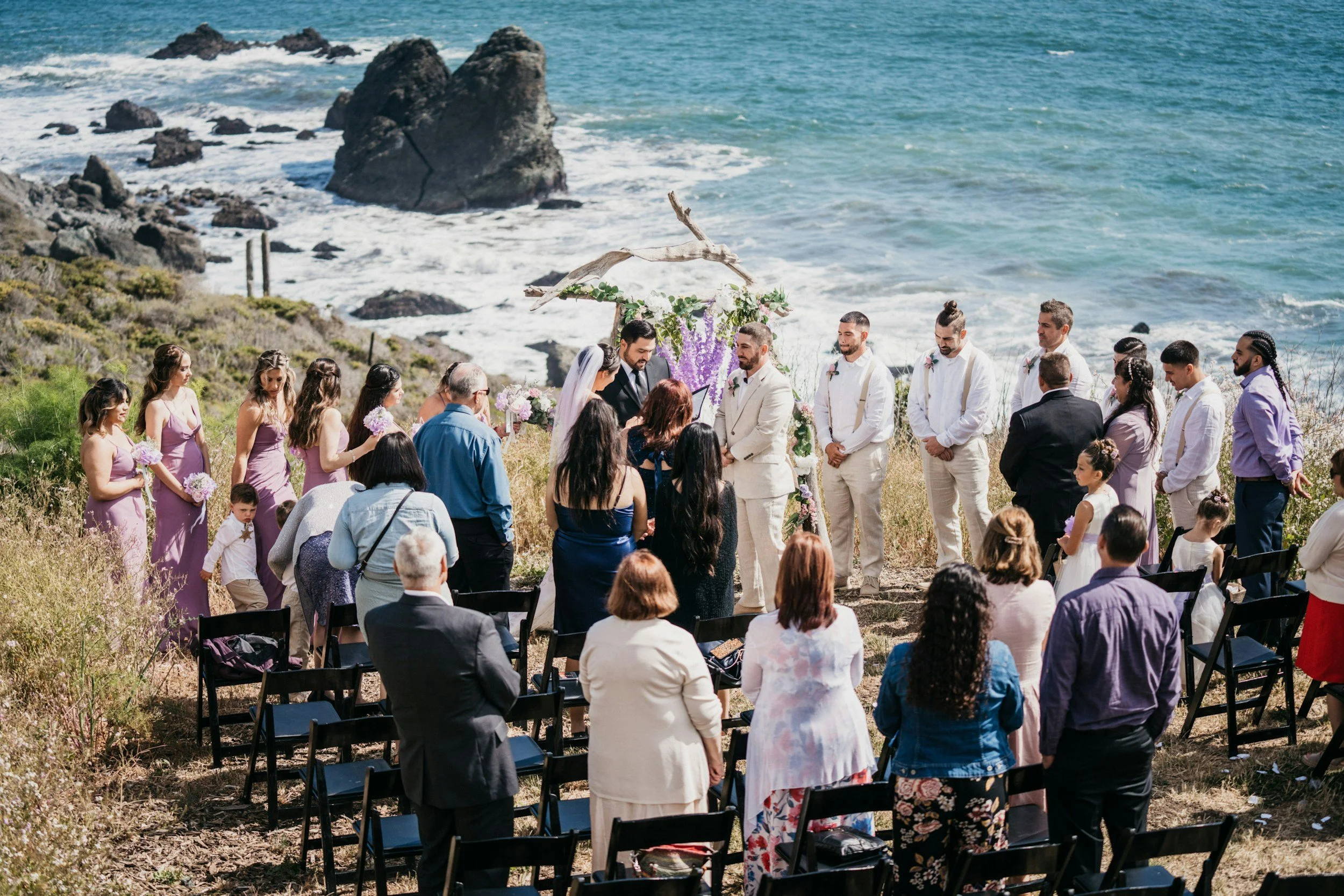 welcoming-wedding-guests.jpgCouple with family and guests gathered together during an outdoor wedding ceremony