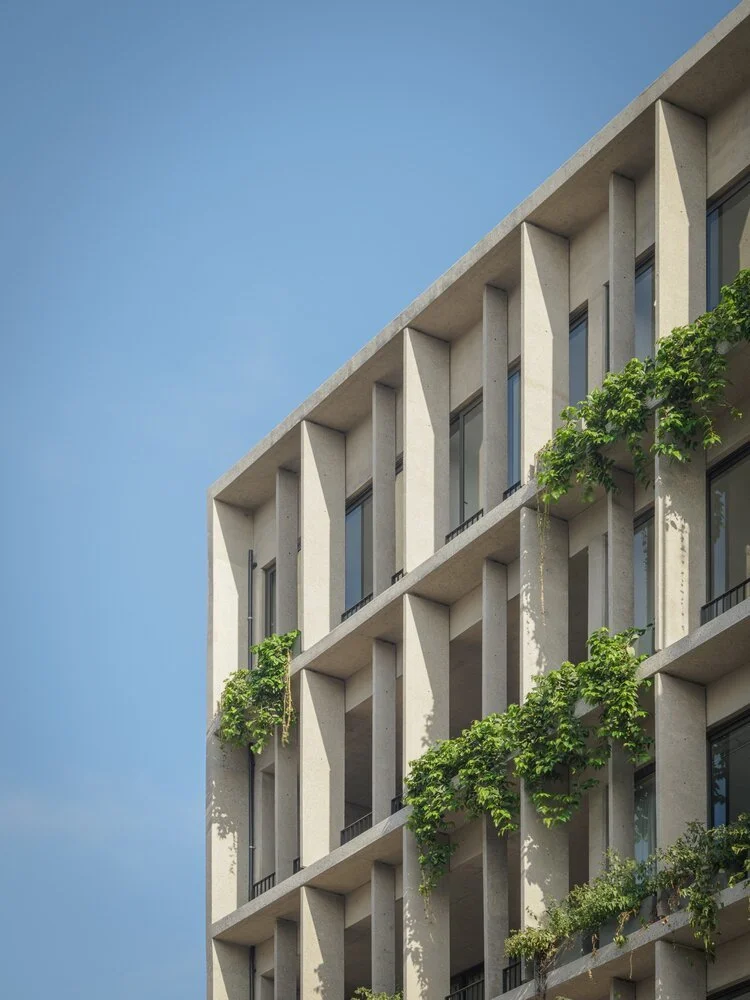 Fachada moderna de edificio con ventanas y plantas verdes en los balcones