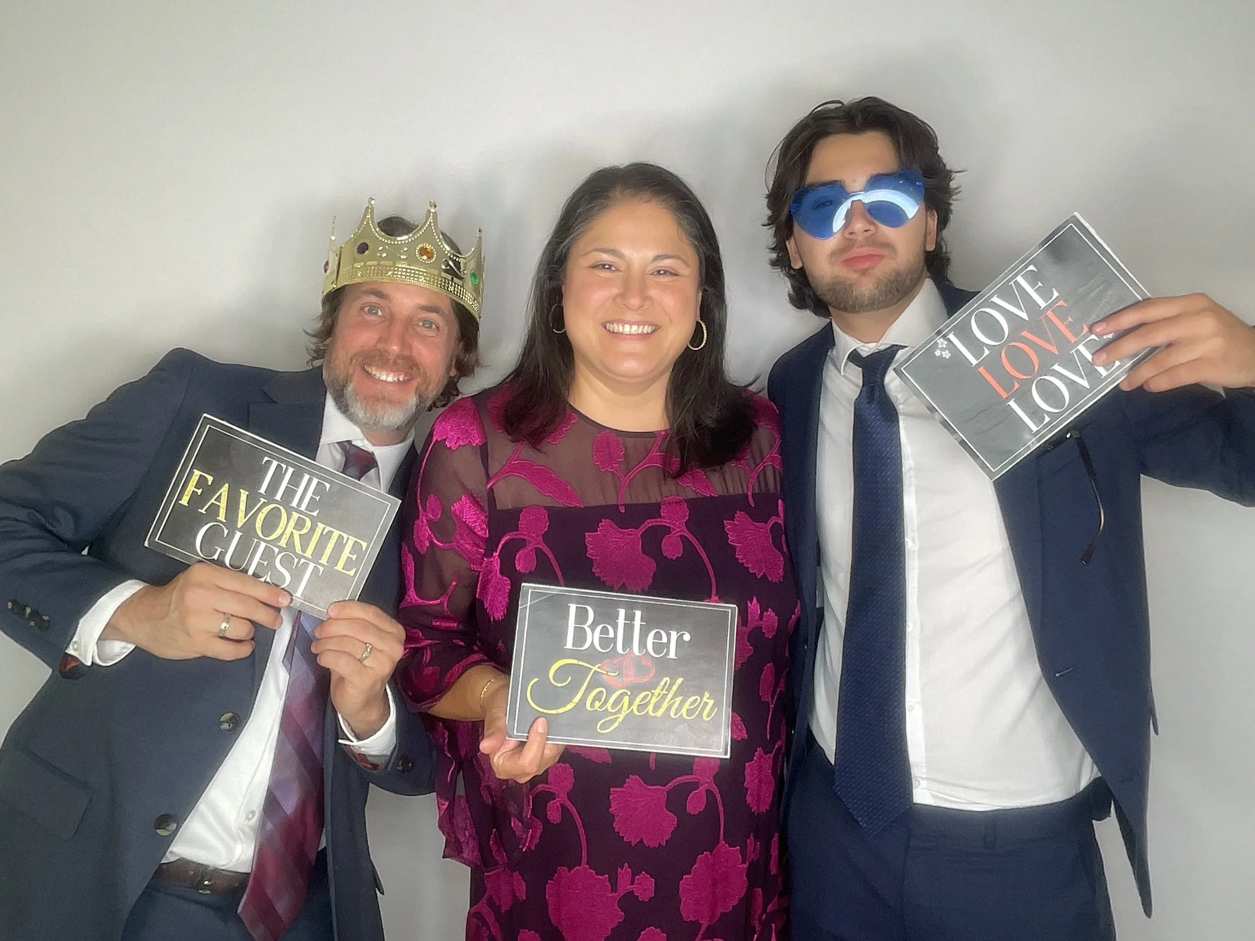 Wedding guests celebrating together with Better Together photo booth signs