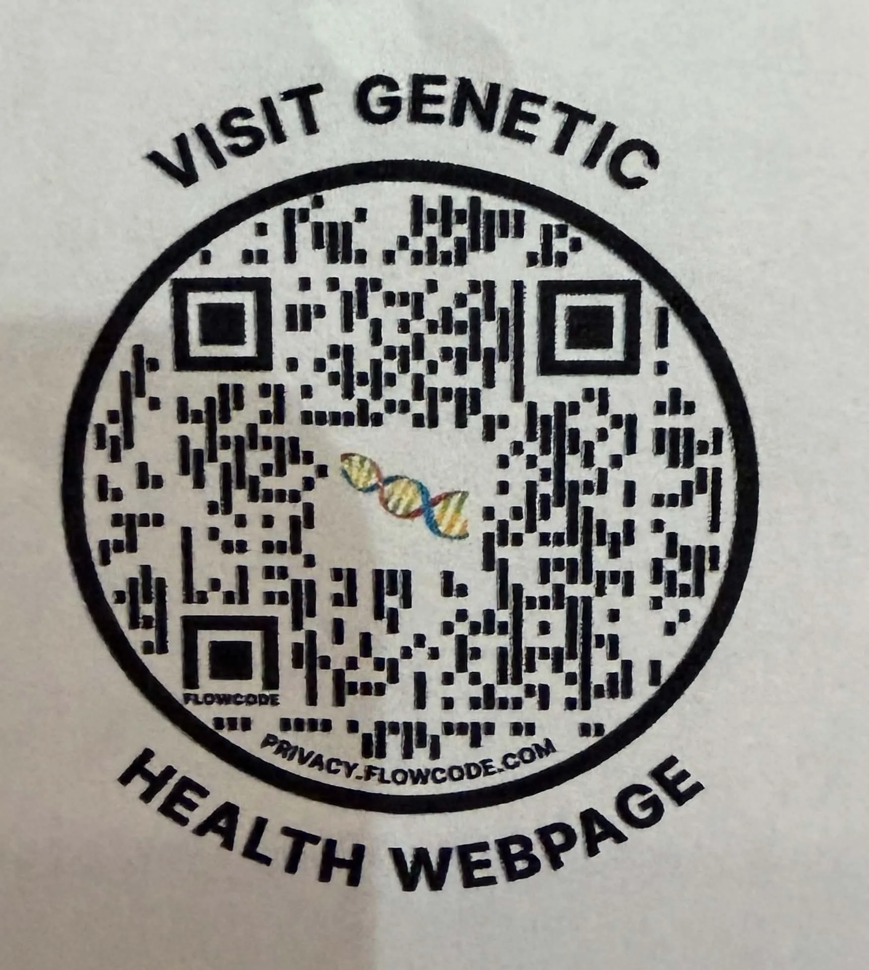 A circular QR code with text above reading 'Visit Genetic' and text underneath indicating the website 'www.flowcode.com'. The QR code features a colorful DNA helix graphic in the center.