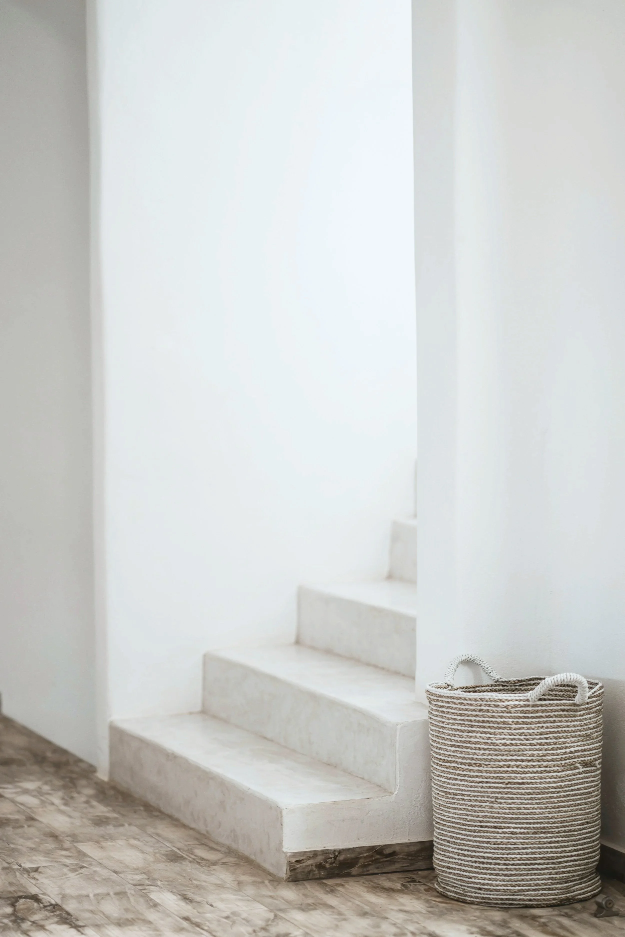 Valkoinen portaikko ja kori lattialla.