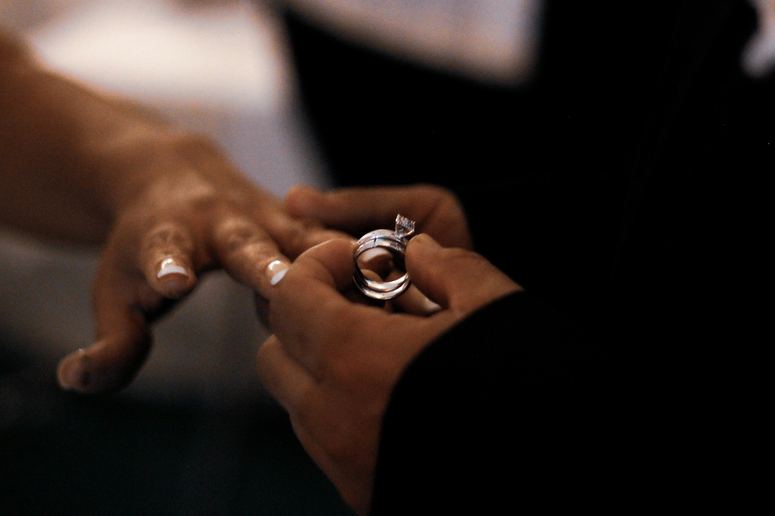 Wedding rings being exchanged during a ceremony representing marriage counseling and relationship support