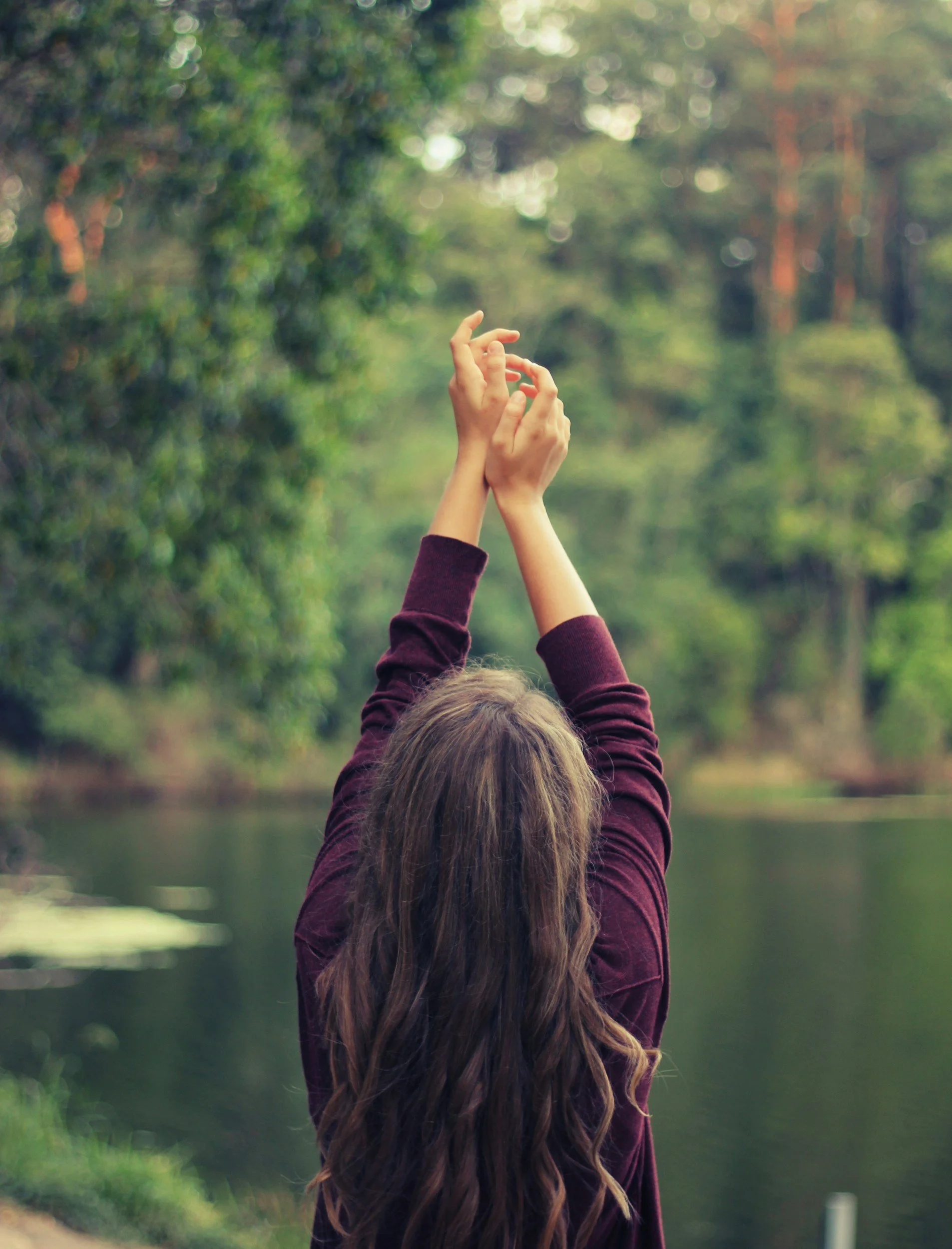 Woman standing outdoors with raised arms representing personal growth through acceptance and commitment therapy