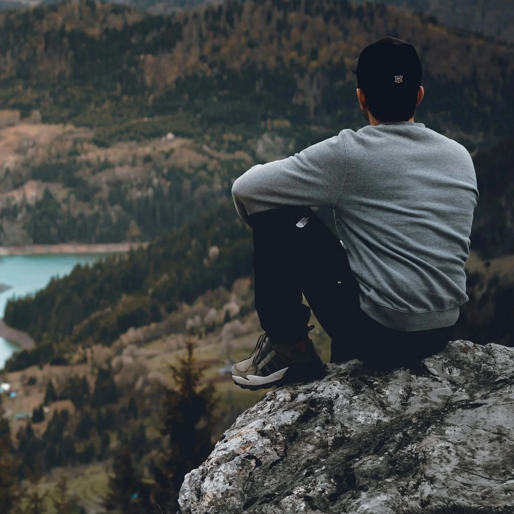Person sitting on a mountain overlook representing depression therapy and emotional healing in California