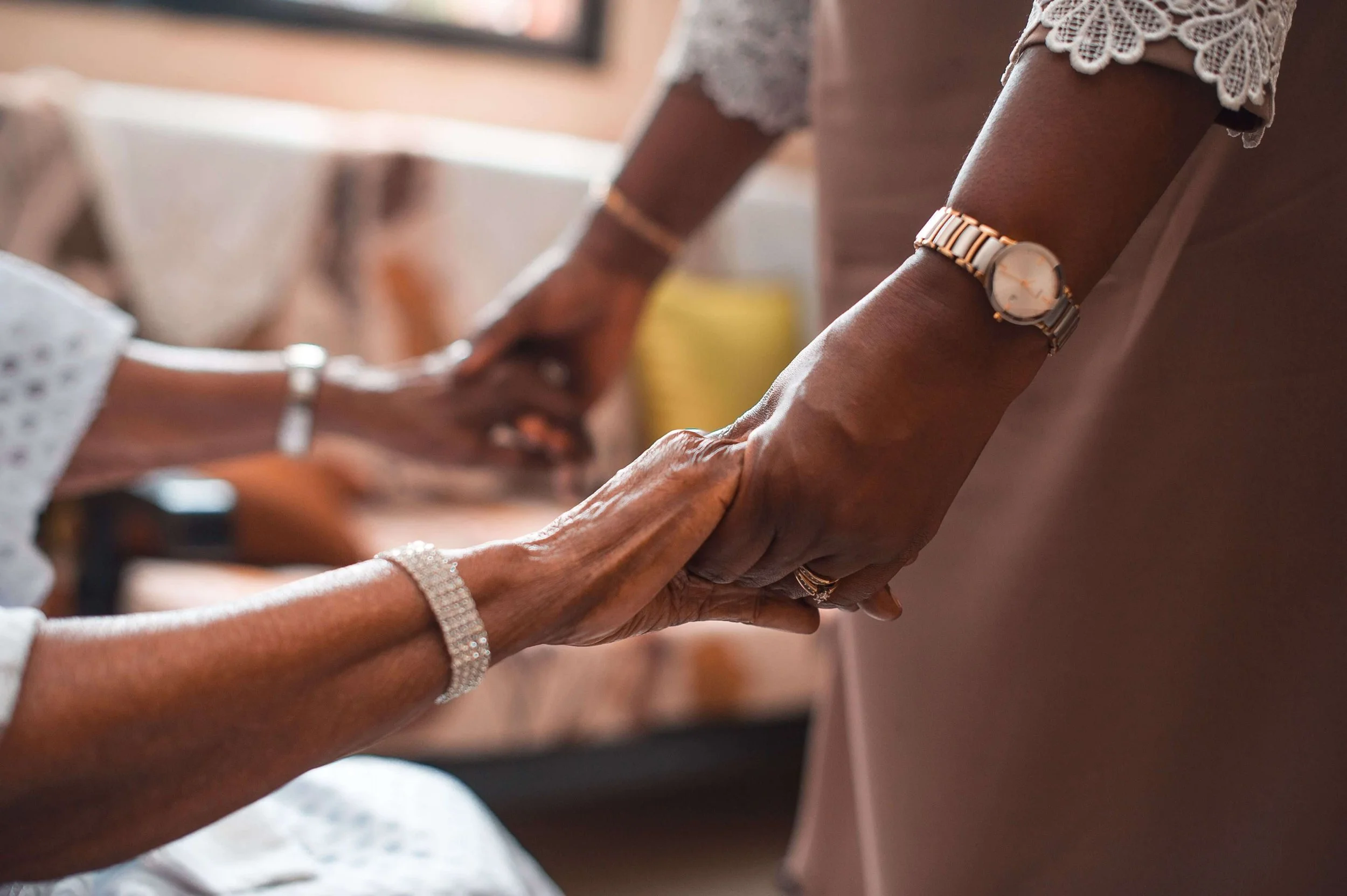 Black women holding hands in support and connection, representing culturally affirming BIPOC therapy in California
