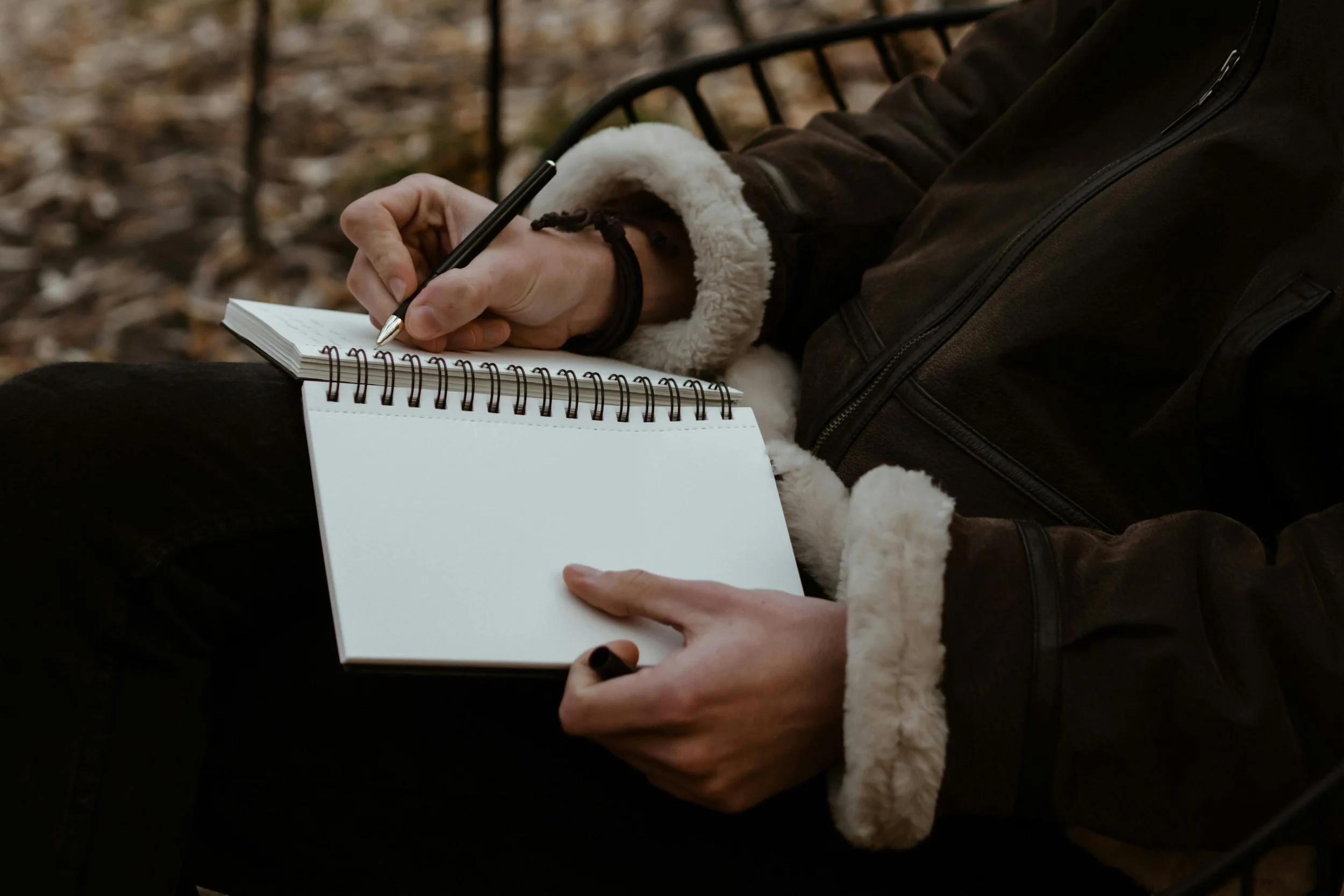Person journaling at a desk while reflecting on family relationships and personal experiences