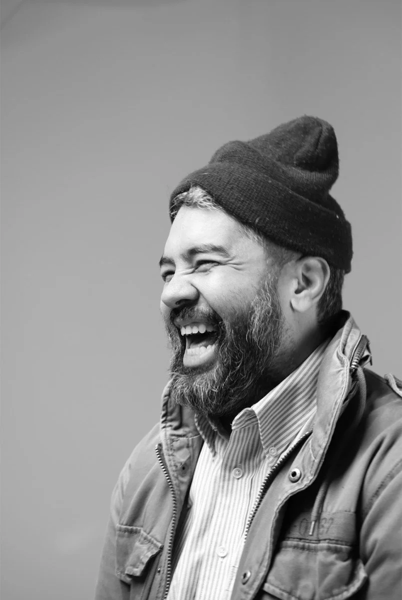 Interview subject in a beanie laughing during a KLTRD MEDIA documentary-style portrait session