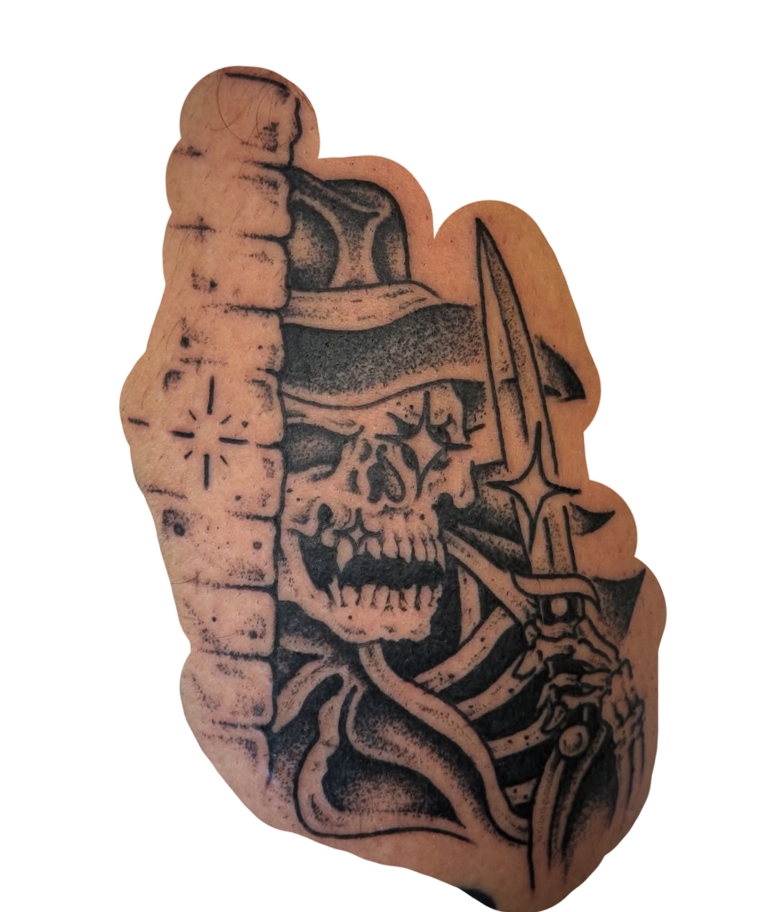 Black and grey tattoo of a skull with a knife