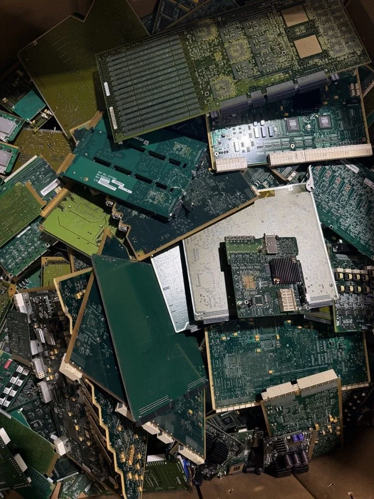 Pile of discarded electronic circuit boards and computer components.