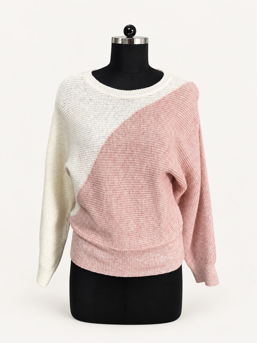 Ivory and blush diagonal colour-block knit sweater with long sleeves, displayed on a dress form.