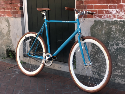 auqa color road bike on a new orlean french quarter sidewalk