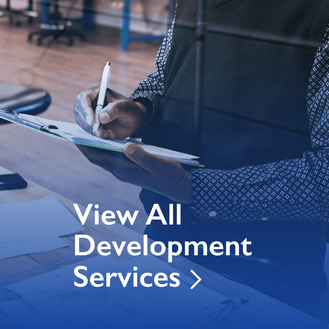 Person writing on a clipboard in an office setting with text overlay: "View All Development Services.