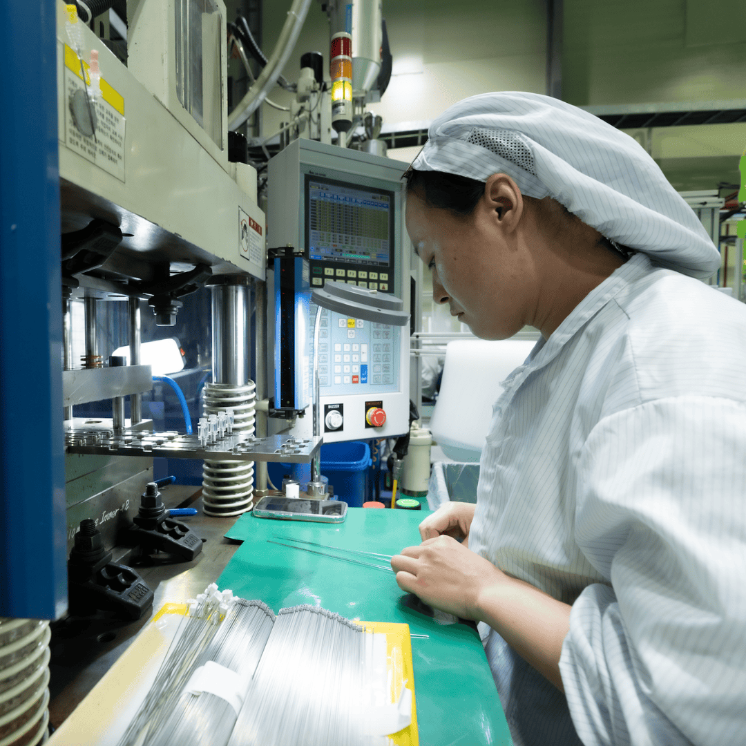 An Elevaris worker operates machinery, monitoring controls on a screen.