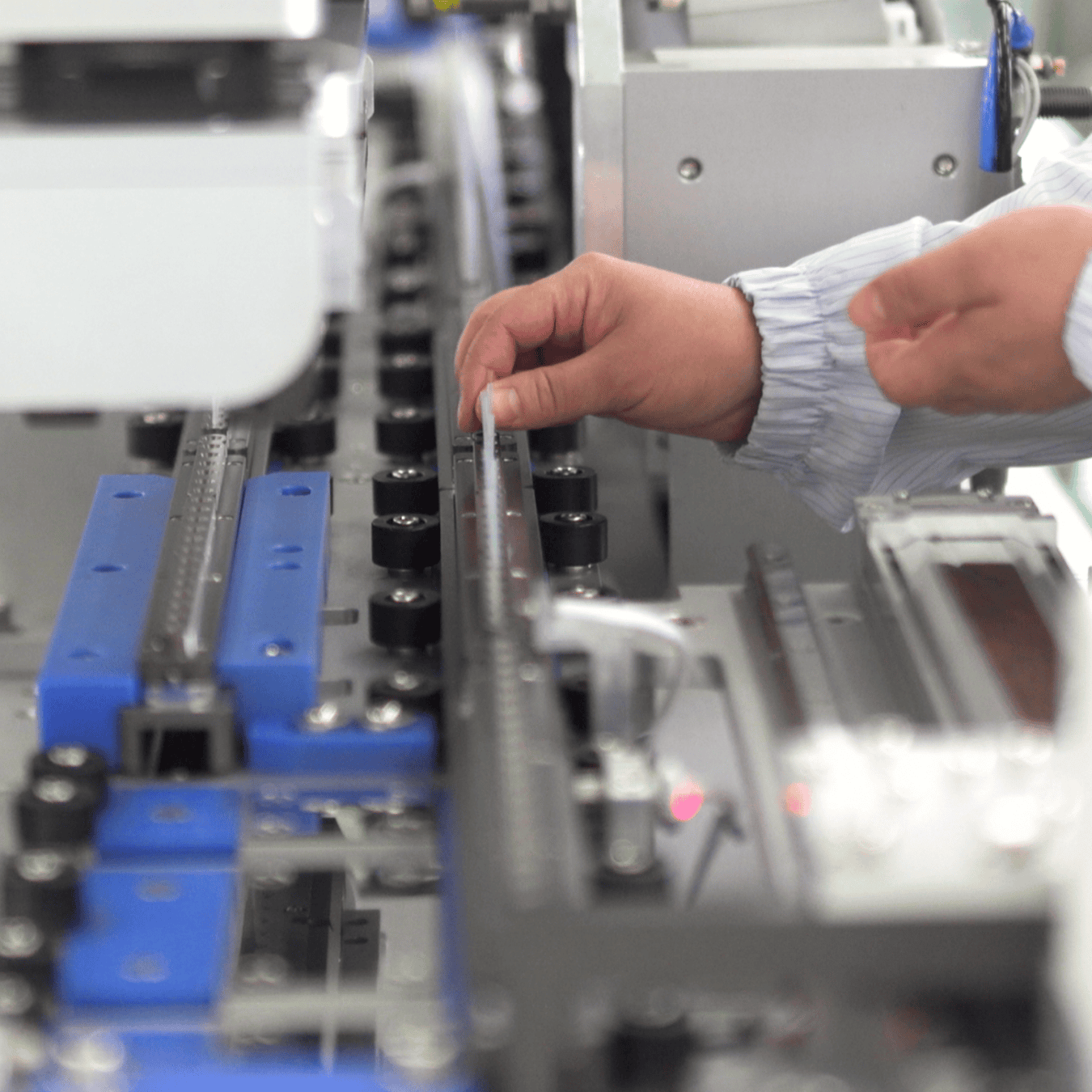 Person working for Elevaris operates machinery on an industrial assembly line.