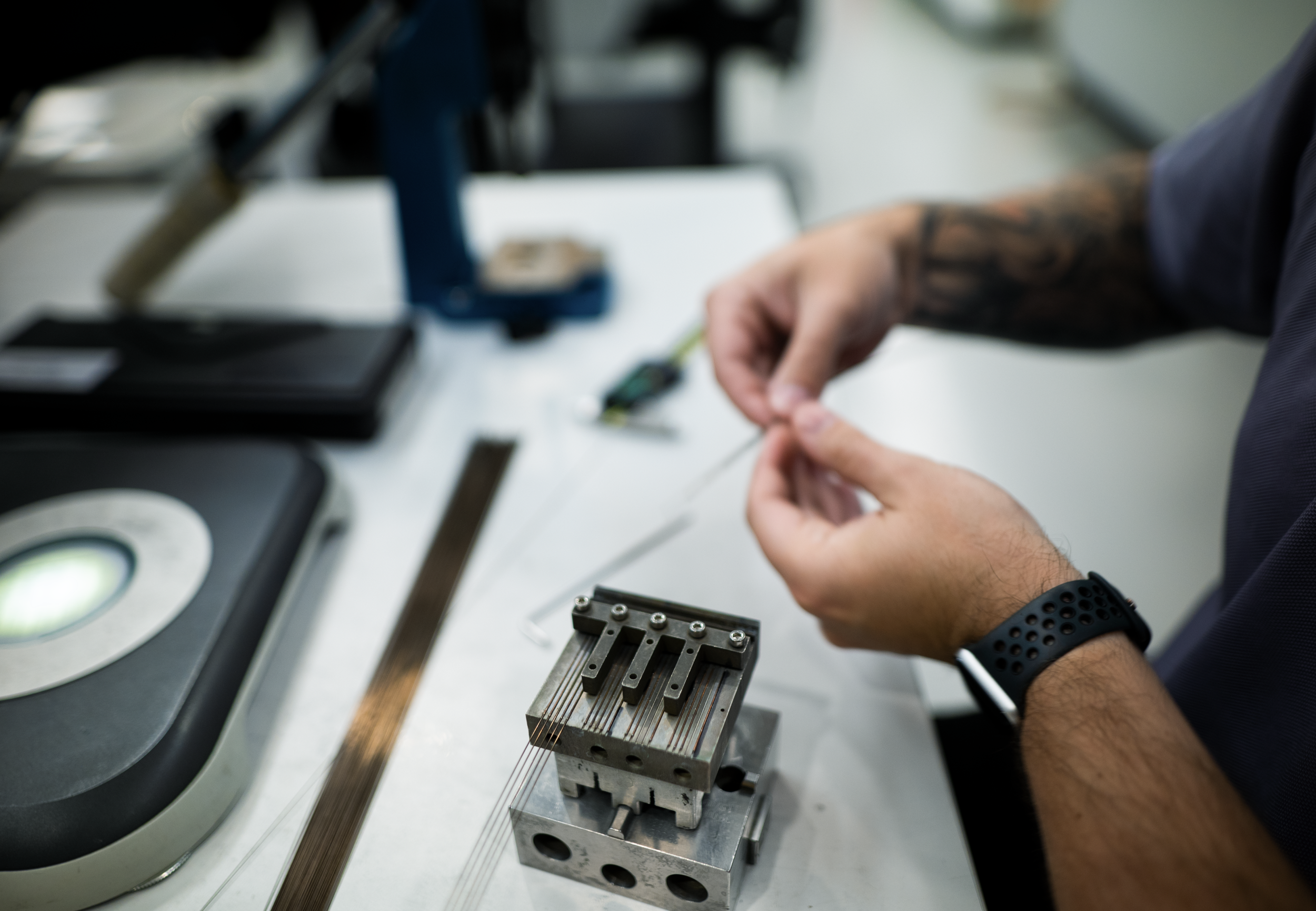 Technician working with small precision medical device components during product development and manufacturing.