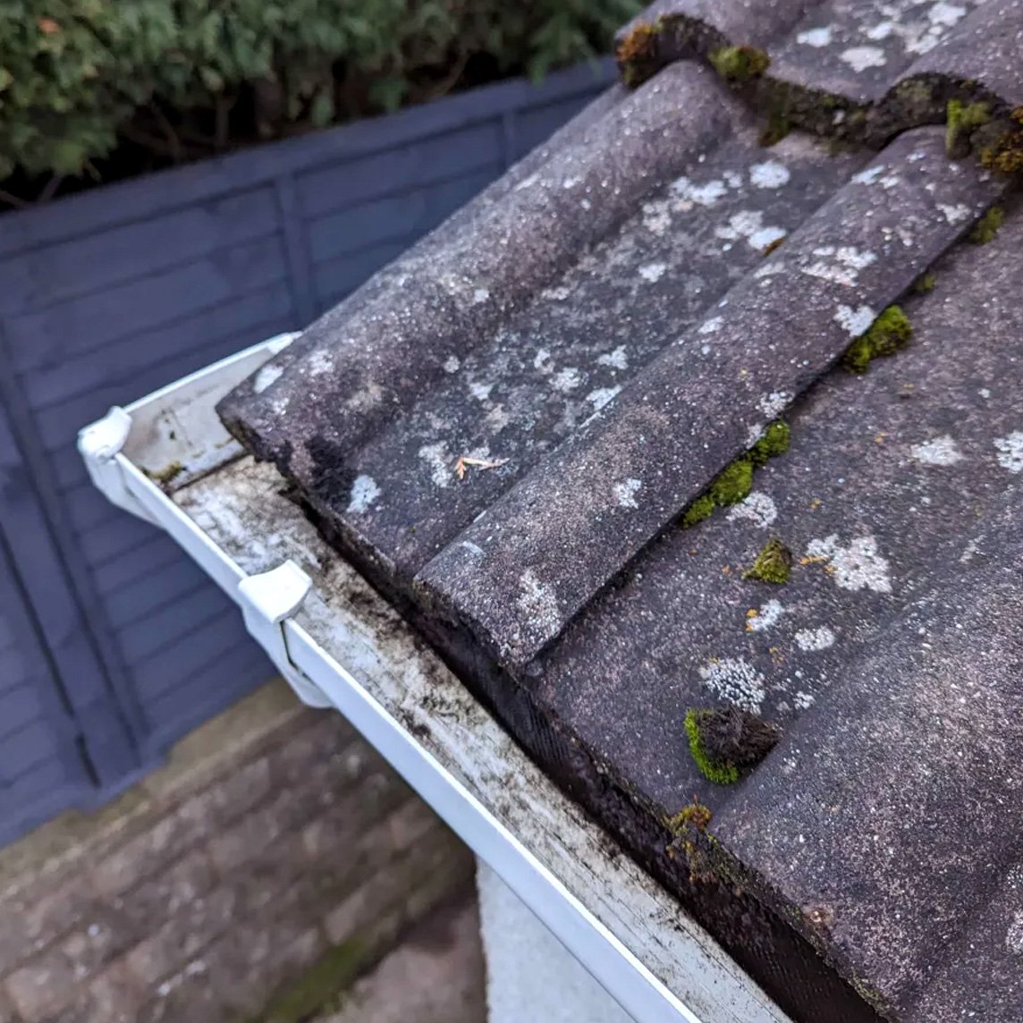 After: Freshly cleared house gutter after professional gutter cleaning by Black Spot Exterior Cleaning and Maintenance, showing restored water flow capacity.