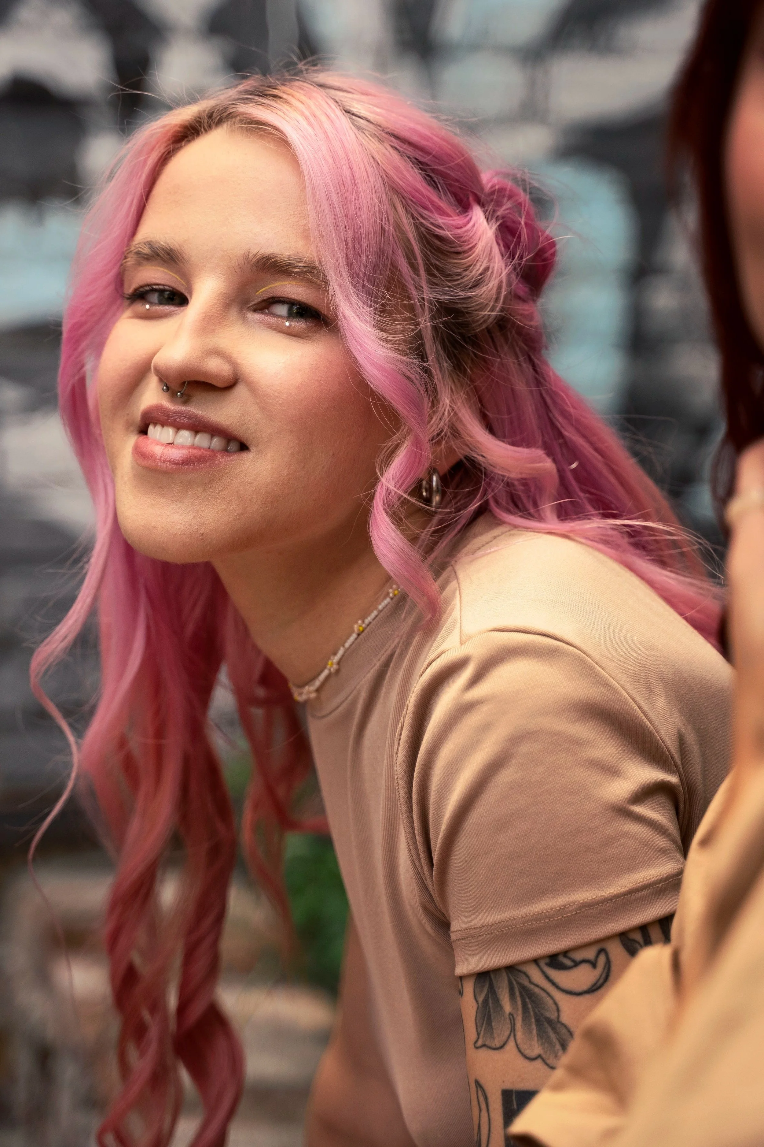 Image of a young woman with pink hair smiling, symbolizing supportive and affirming care for Gender-Affirming Surgery Letters service at Guidance Teletherapy
