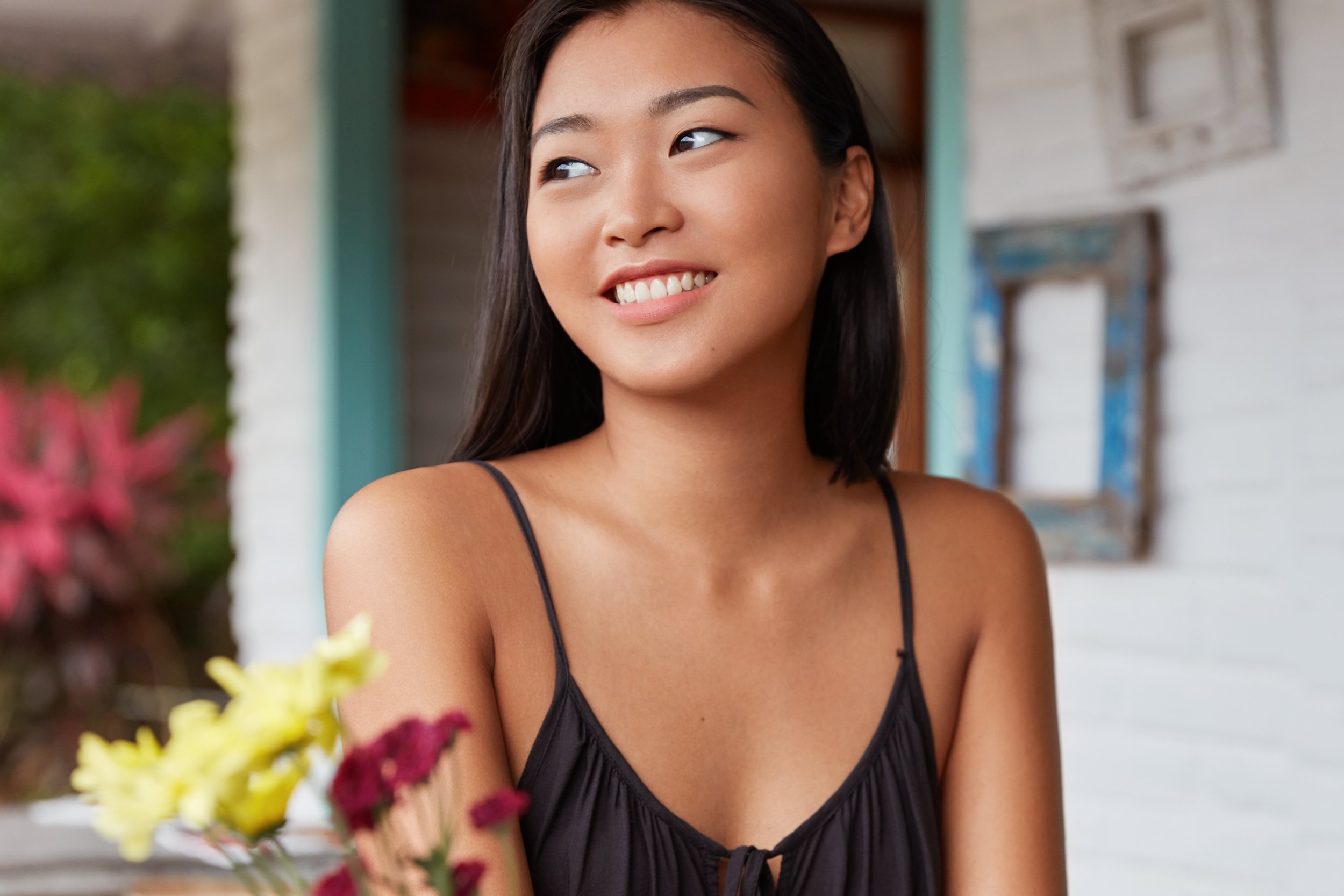 Person smiling warmly while seated in a cozy coffee shop reflecting a sense of calm after finding support through therapy at Guidance Teletherapy