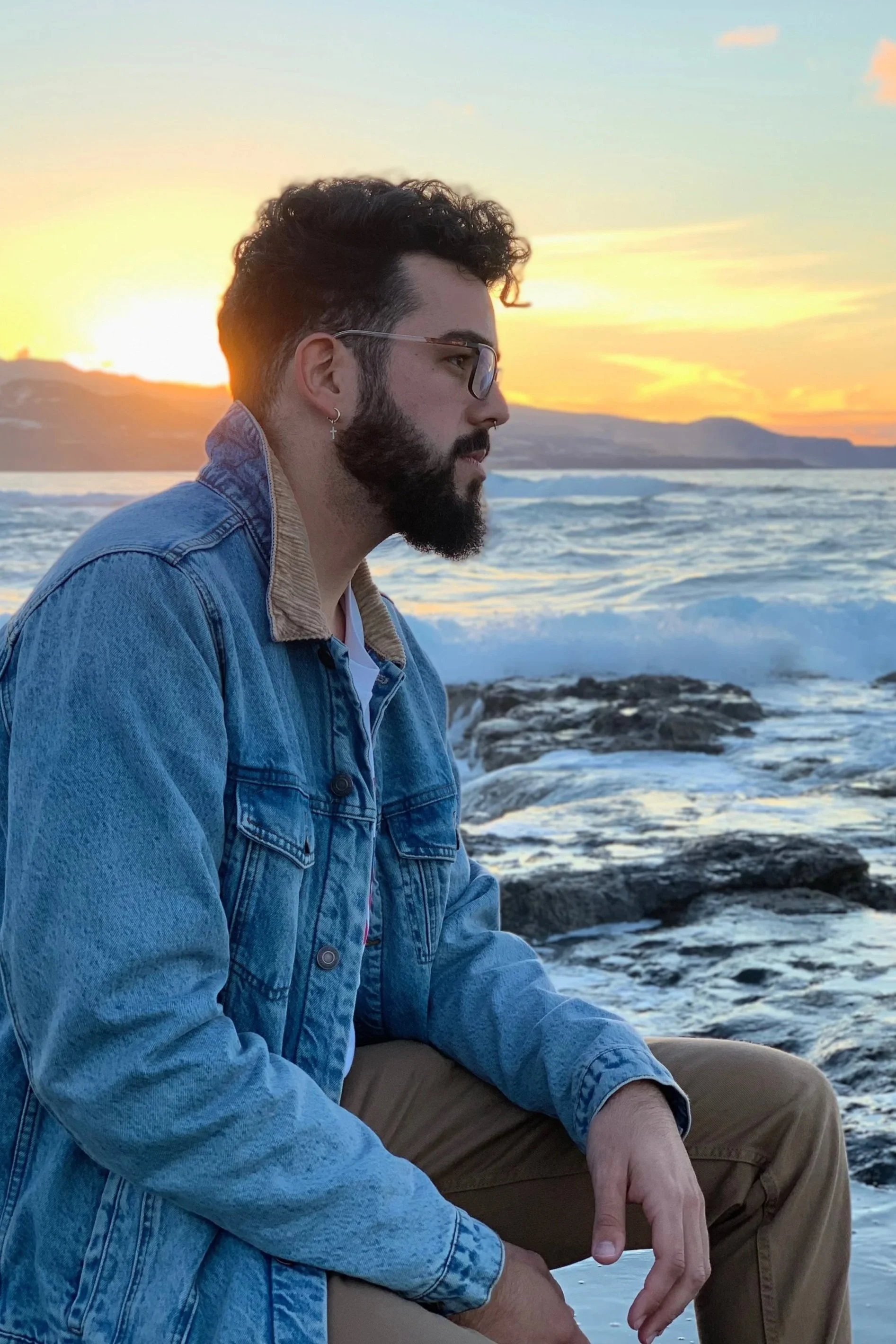 Man sitting on the beach at sunset reflecting on personal growth and transformation symbolizing the calm insight and integration supported through Psychedelic-Assisted Psychotherapy with Guidance Teletherapy