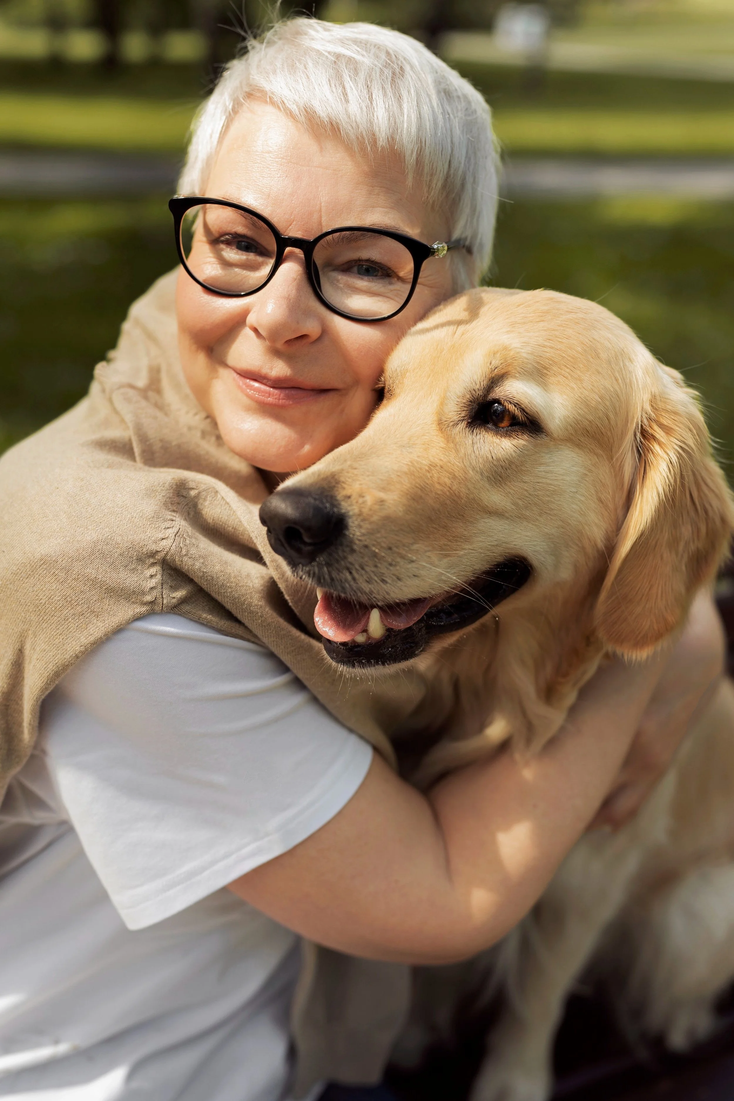 Older adult smiling while sitting with their dog showing comfort companionship and emotional support gained through an emotional support animal assessment with Guidance Teletherapy