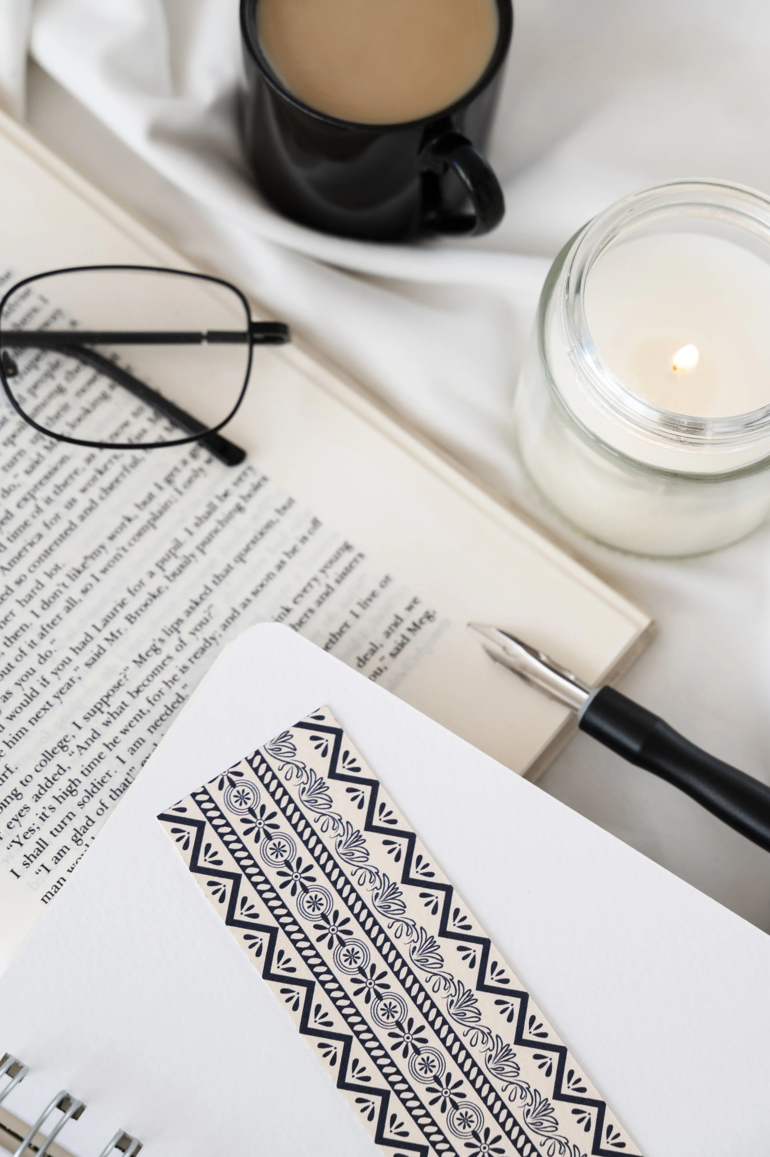 Image of a coffee cup, open book, and bookmarks viewed from above, representing self-guided learning and helpful blog resources from Guidance Teletherapy, linked to the Blog
