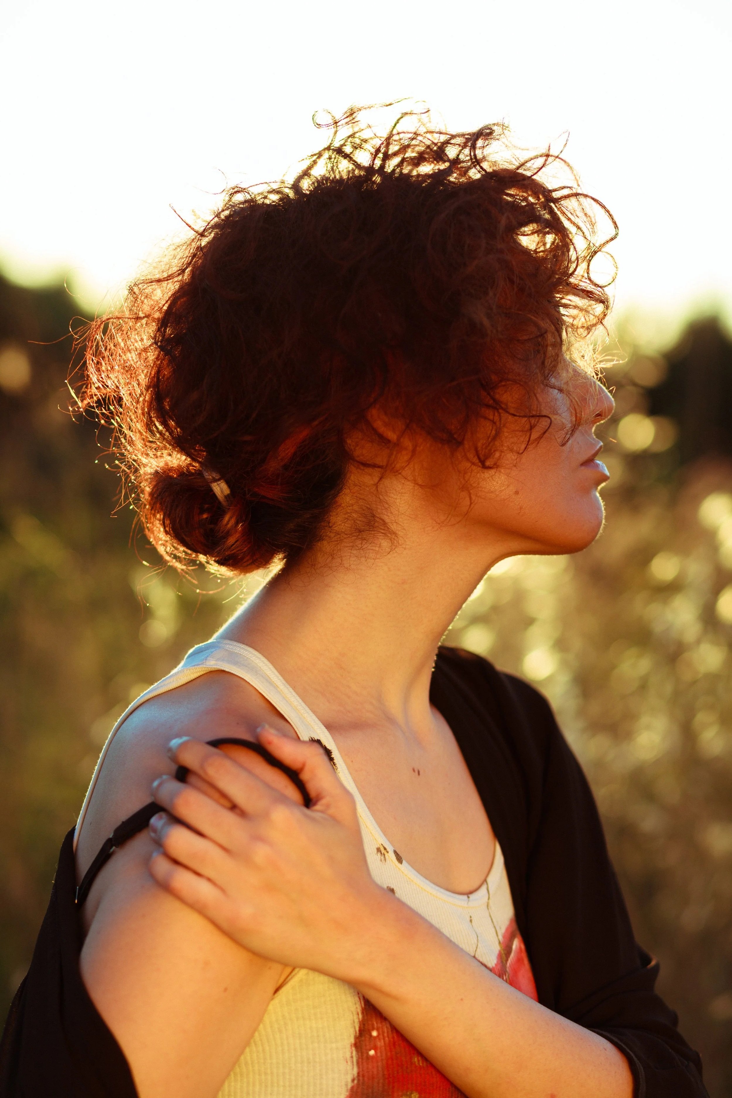 Young woman pausing outdoors with a calm expression, reflecting on mindfulness techniques learned through Guidance Teletherapy’s Empowered Relief program